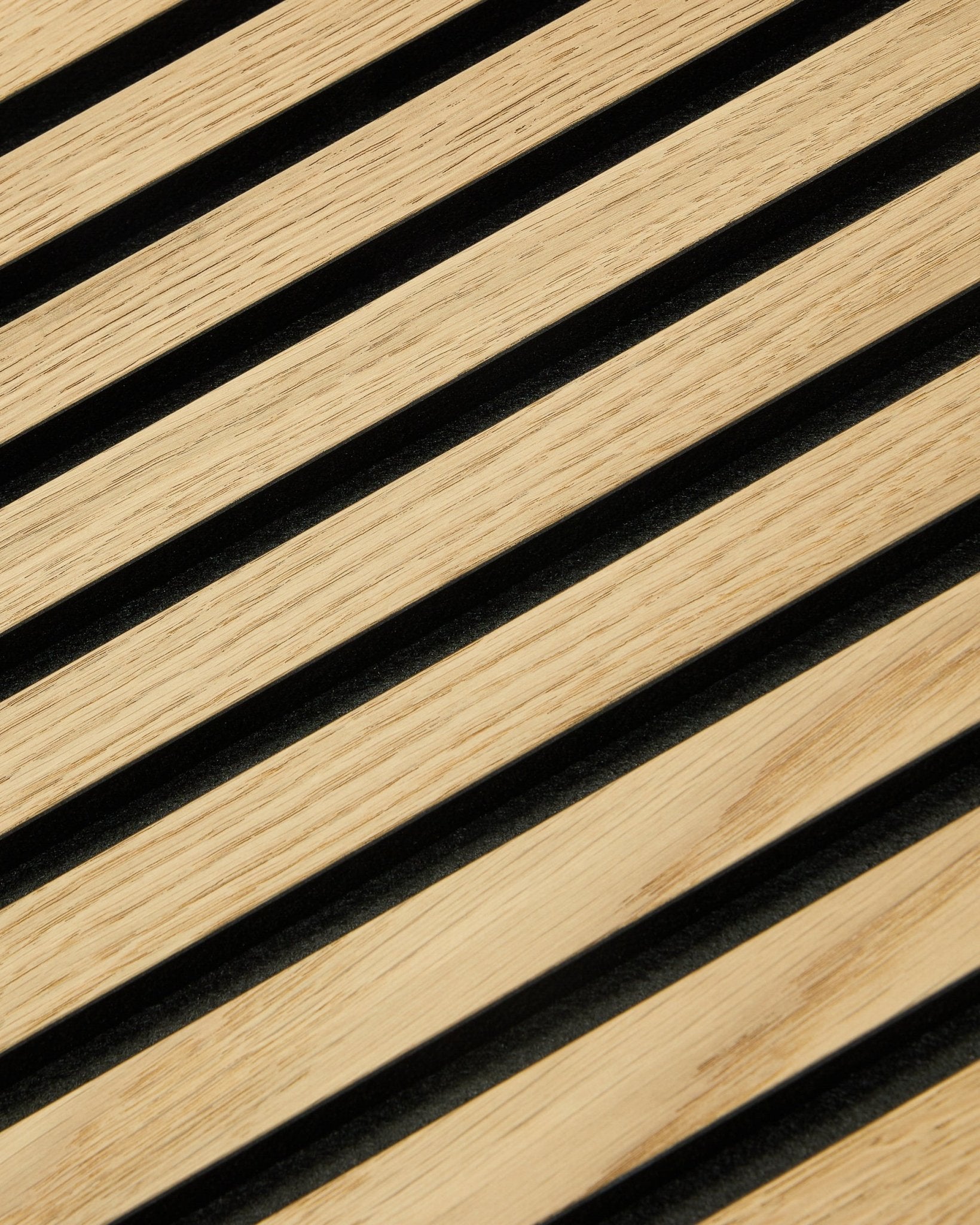 Gros plan sur WoodUpp Original Akupanel Panneau acoustique avec des lattes Classic Oak, un support en feutre black et du MDF, format 300x60 cm pour des intérieurs nordiques modernes.
