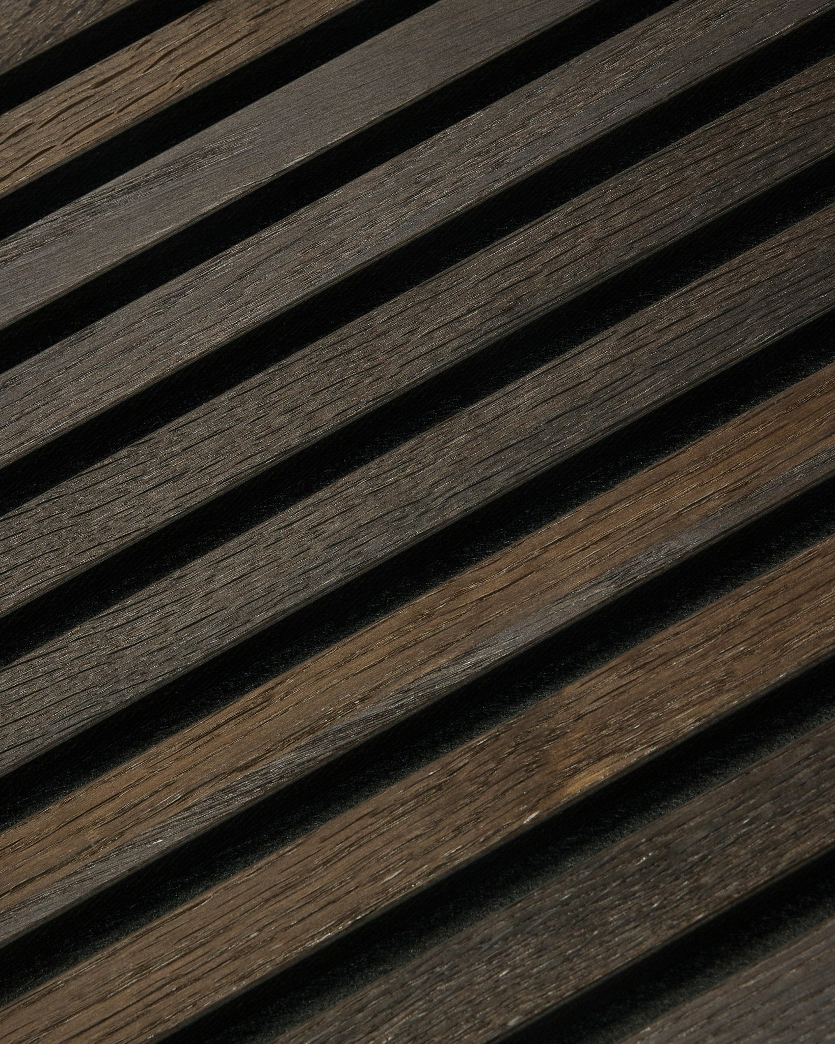 Gros plan sur le panneau WoodUpp Rustic Akupanel Panneau acoustique en Smoked Oak (300x60 cm), mettant en valeur le veinage visible du bois, un style nordique minimaliste et un motif d’ombres linéaires.
