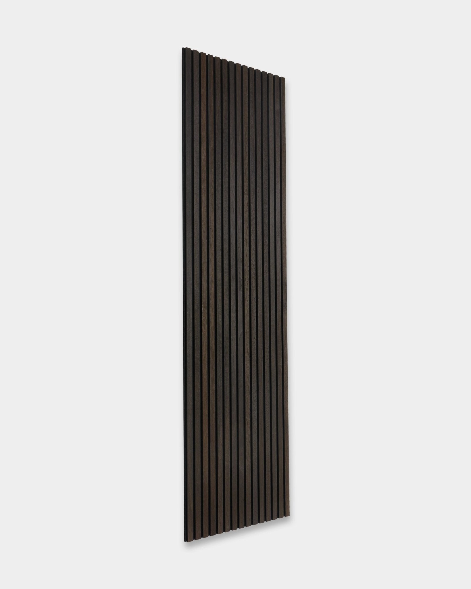 Smoked Oak rustique Akupanel Panneau acoustique de WoodUpp, avec des lattes en bois foncé vertical, appuyé contre un mur gris clair.