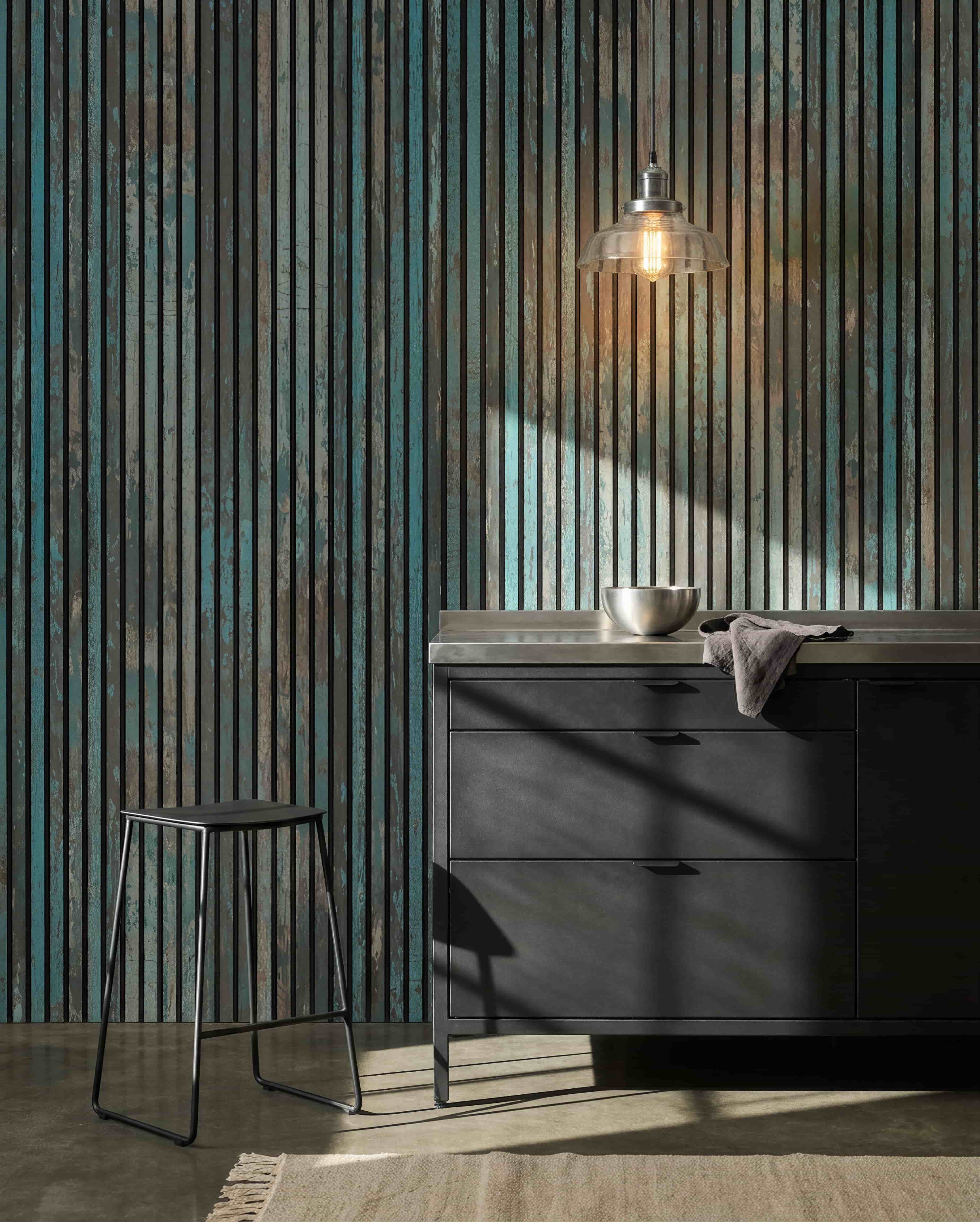 Cuisine moderne avec des tabourets black, des meubles black, un bol sous une suspension, et un Panneau acoustique WoodUpp Akupanel Bleu oxyde au mur pour un meilleur confort acoustique.