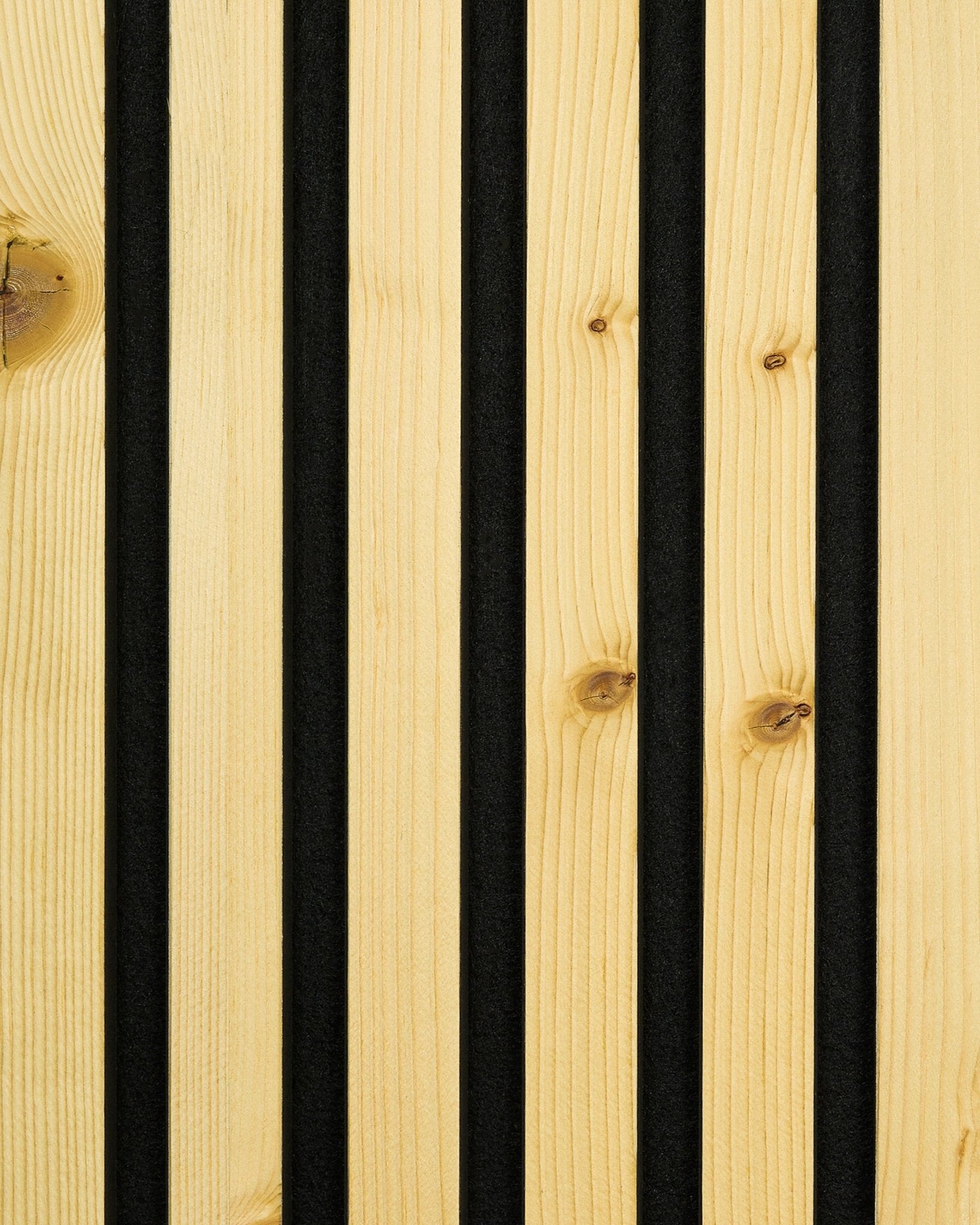Gros plan sur un échantillon WoodUpp Akupanel dans la finition Rustic Alp, avec des rainures vertical black qui séparent des lattes en bois clair, pour un design nordique Panneau acoustique.