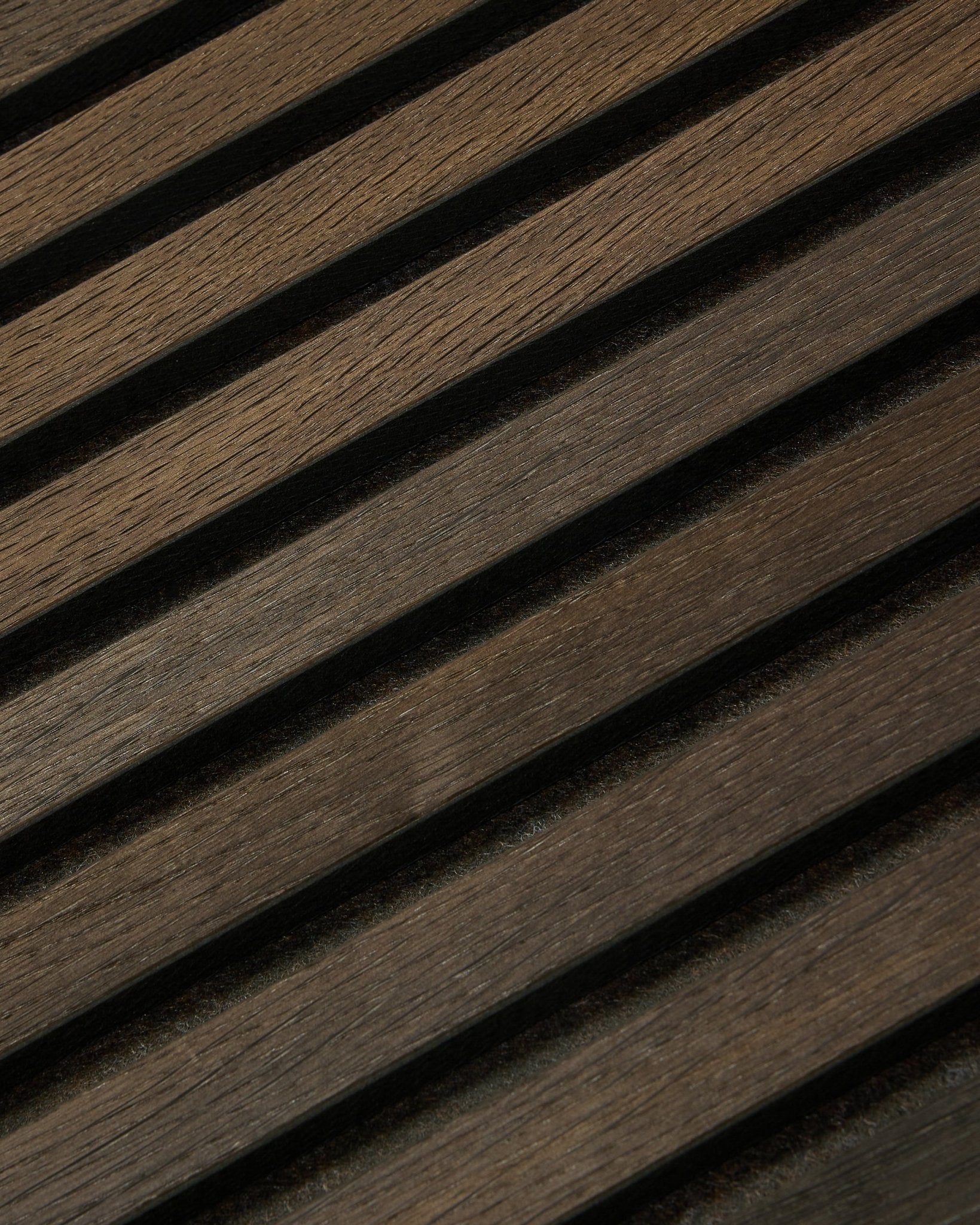 Gros plan sur le Tonal Akupanel Panneau acoustique en Smoked Oak (240 x 60 cm) de WoodUpp, avec des lattes nordiques diagonales et texturées dans un style scandinave.