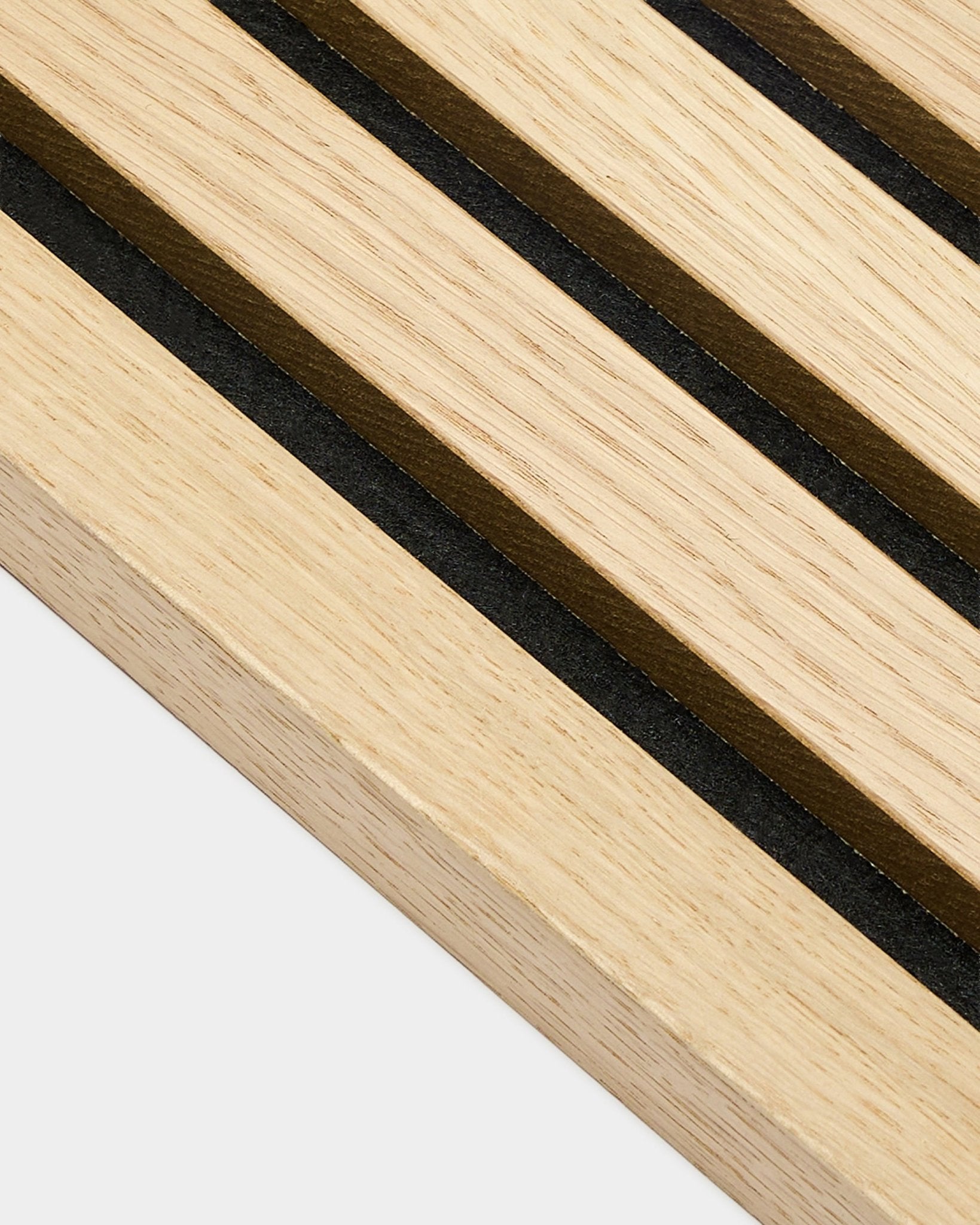 Gros plan sur la lamelle d’extrémité WoodUpp Akupanel en chêne classique, épaisseur 2,2 cm, avec des rayures parallèles black et brown, caractéristiques des panneaux acoustiques nordiques.