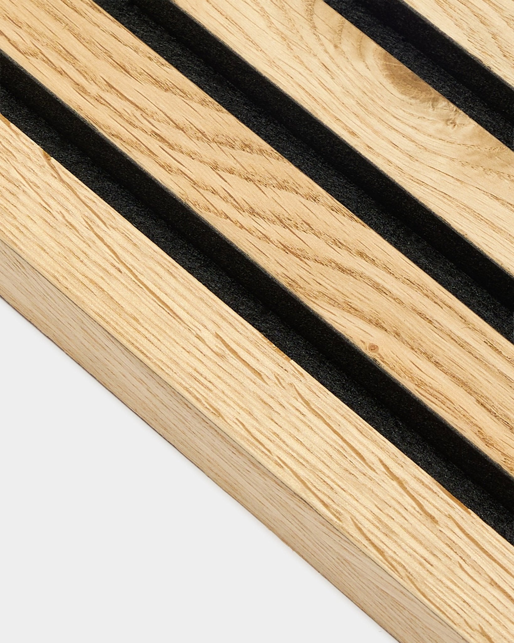 Gros plan sur la lamelle d’extrémité WoodUpp Akupanel en natural oak rustique, épaisseur 2,2 cm, avec des rainures diagonales black et une texture de grain natural wood visible.
