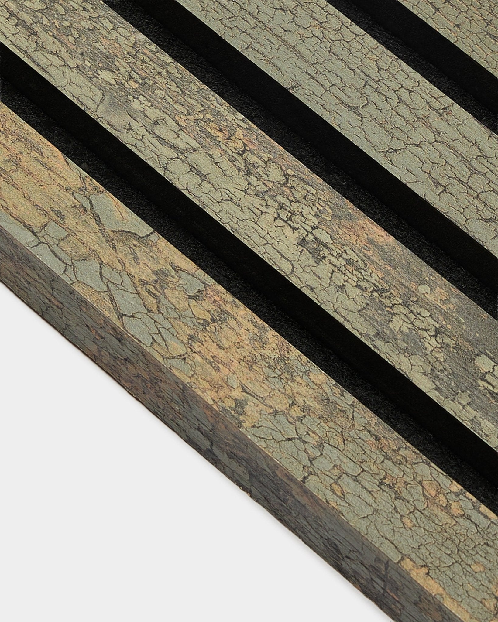 Gros plan sur la lamelle de finition WoodUpp Akupanel en Oxide Grey, 2,2 cm, montrant la Panneau acoustique texturée avec des rainures black sur une surface aux tons terreux.