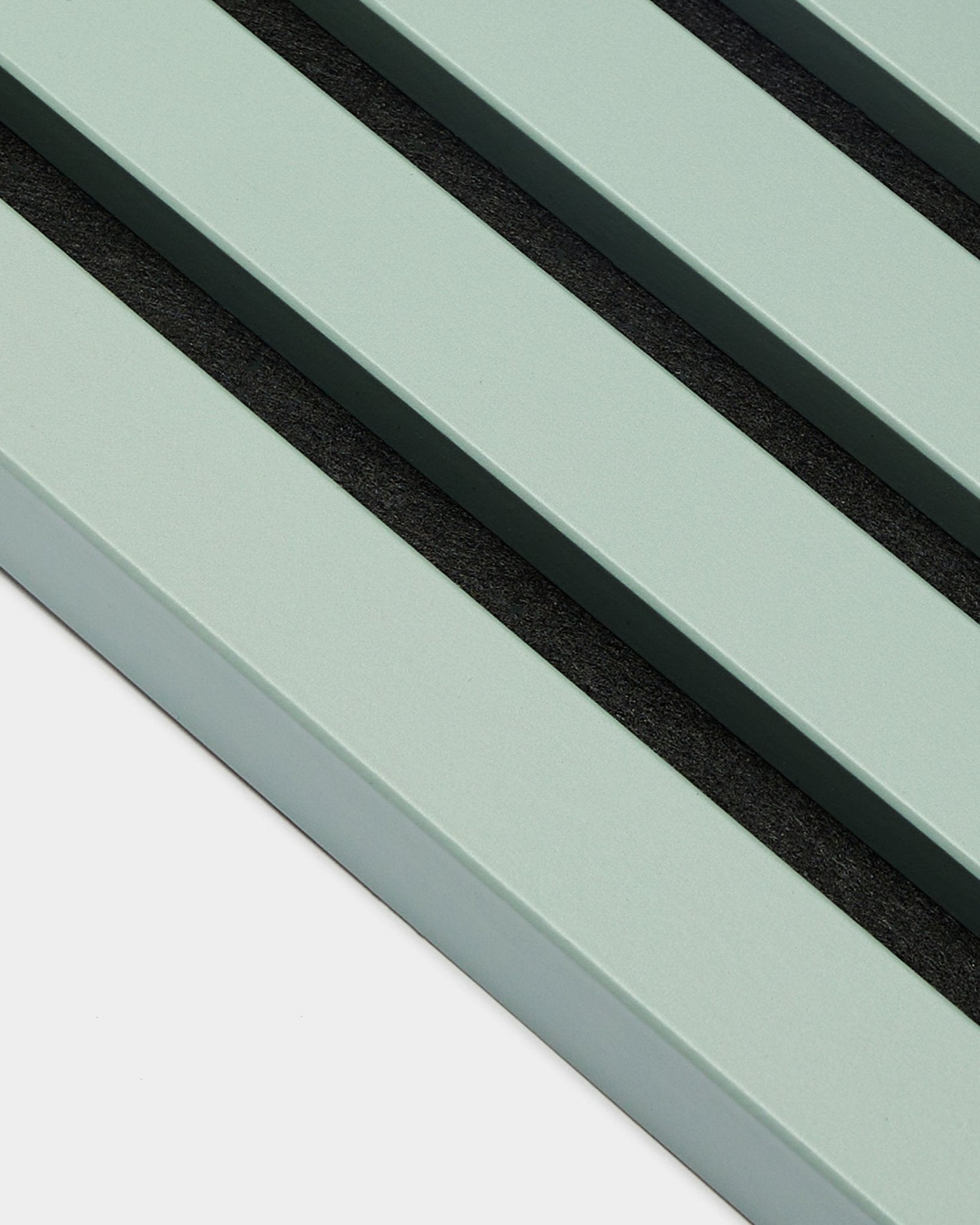 Gros plan sur trois lamelles d’extrémité parallèles vert pastel / Cloud, de 2,2 cm de large, signées WoodUpp, dans le cadre d’une installation Akupanel Panneau acoustique sur fond clair.