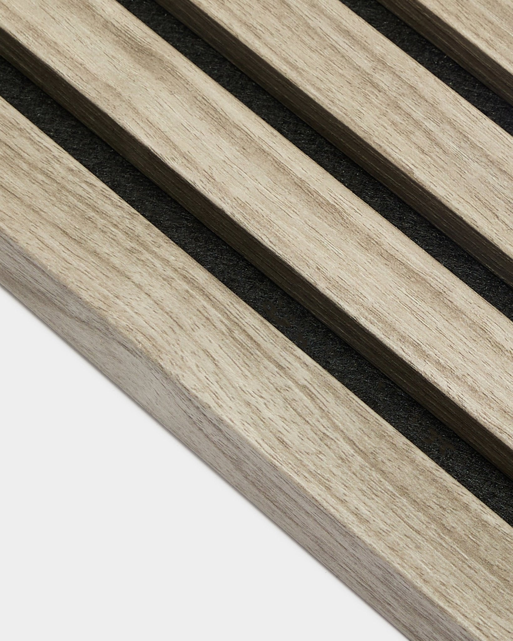 Gros plan sur la lamelle d’extrémité WoodUpp Akupanel en chêne vieilli, 2,2 cm — des lattes acoustiques en chêne nordique clair avec support en feutre black sur fond blanc.