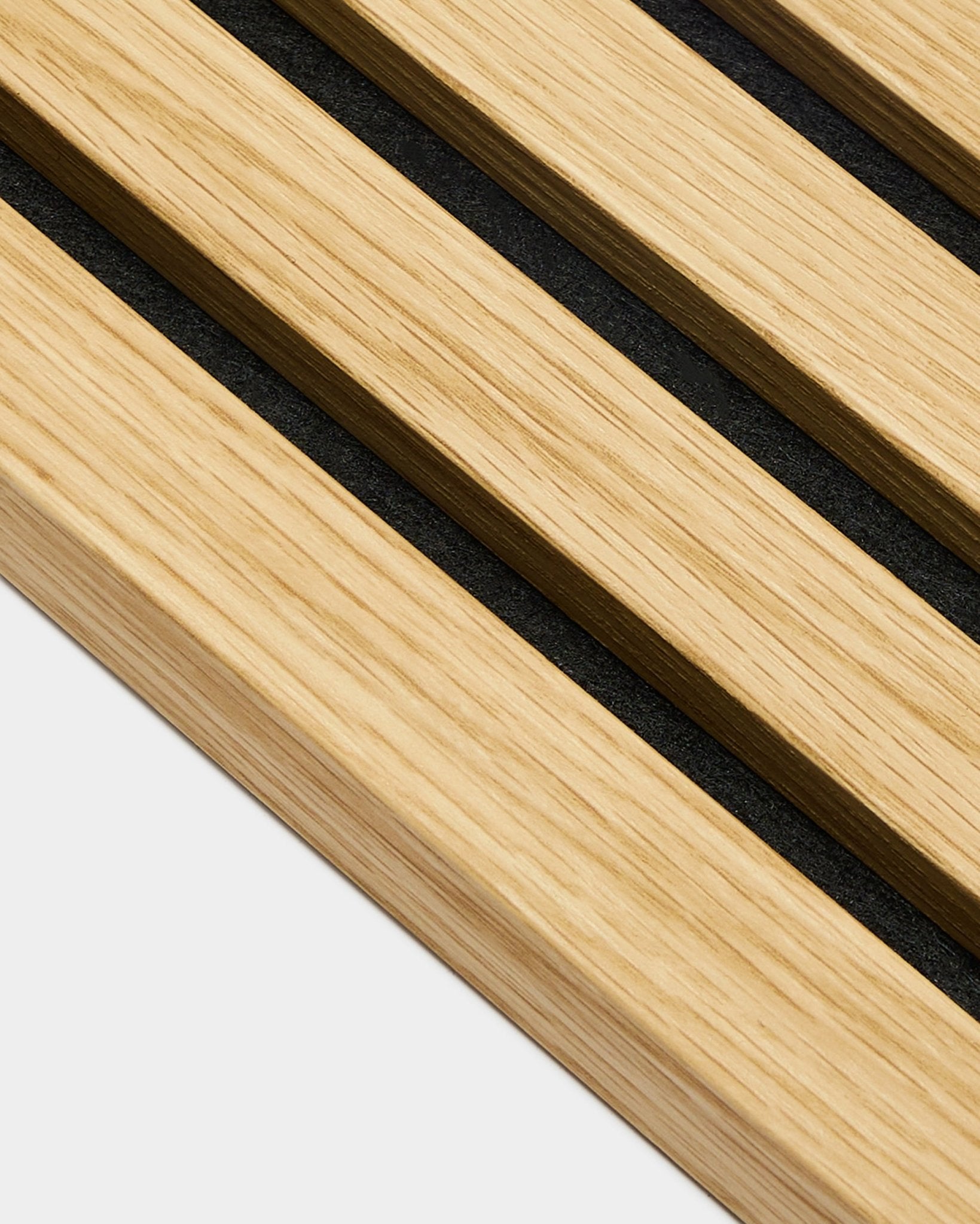 Gros plan sur la lamelle de finition WoodUpp Akupanel en chêne du Sud, avec des lattes de 2,2 cm de large et des espaces de black, disposées en diagonale sur un fond grey clair.