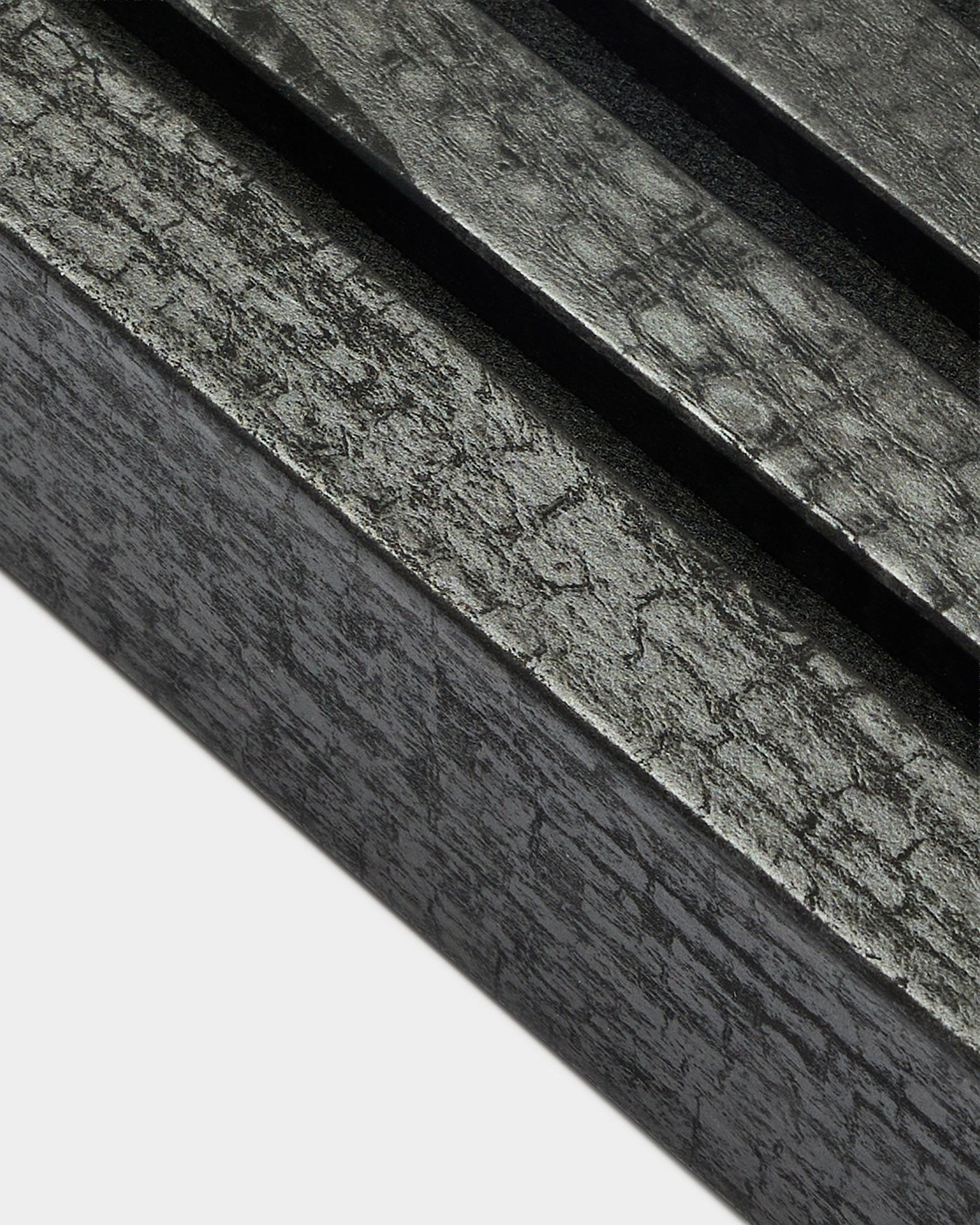 Gros plan de la lamelle de finition WoodUpp Akupanel en Charcoal, largeur 6,7 cm, avec des lattes acoustiques parallèles et une texture de bois au grain distinctif.