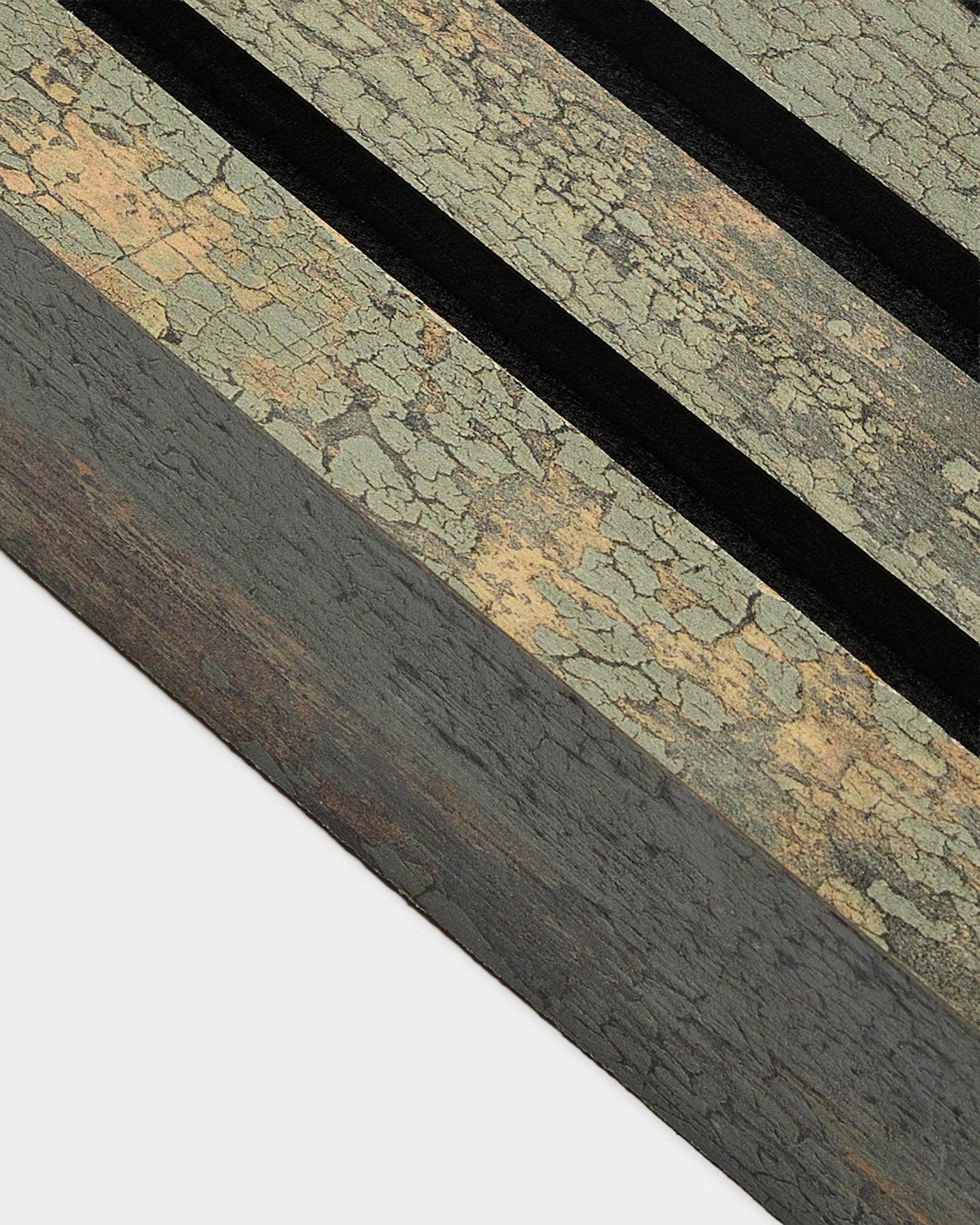 Gros plan sur la lamelle d’extrémité WoodUpp Akupanel en Oxide Grey, large de 6,7 cm, avec une surface Panneau acoustique texturée, deux rainures black et un cadre en MDF.