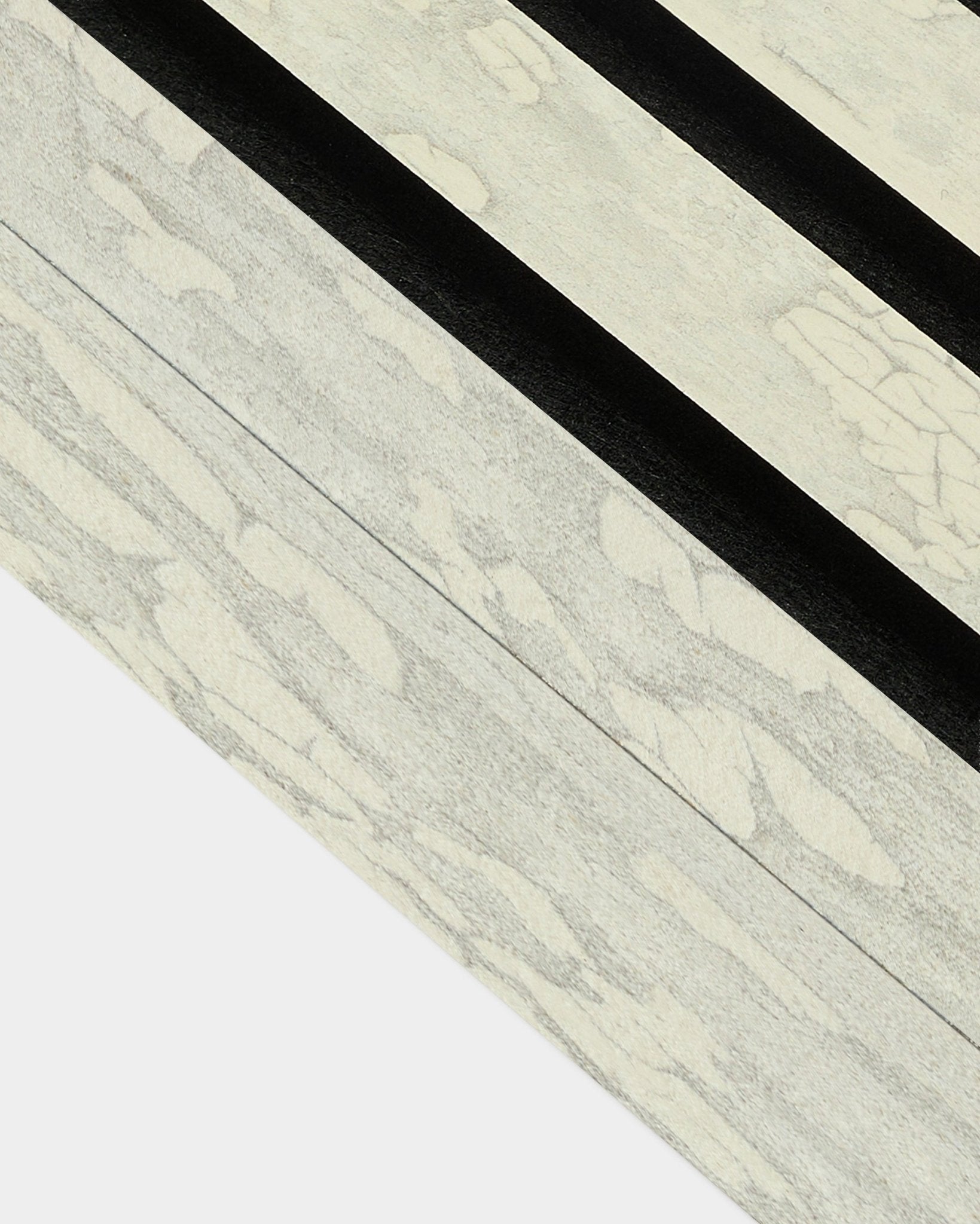 Gros plan sur la lamelle de finition Oxide White (6,7 cm) de WoodUpp pour l’installation Akupanel Panneau acoustique, avec des motifs diagonaux marqués black dans un esprit nordique.