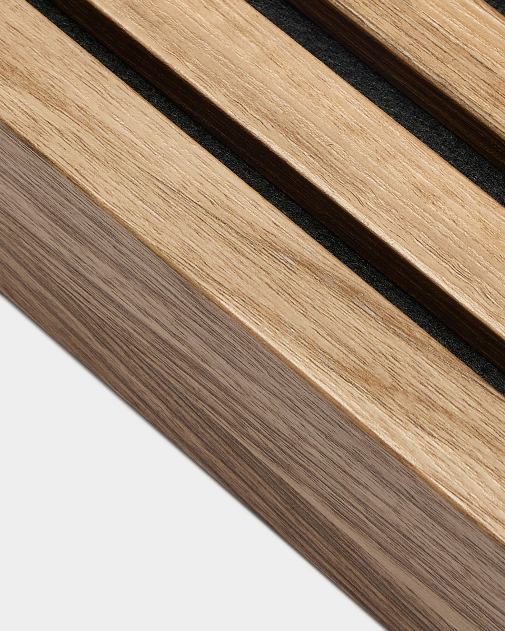 Gros plan sur la lamelle de finition WoodUpp Akupanel en noyer anglais (6,7 cm), montrant les espaces black entre les lattes acoustiques sur fond blanc uni.