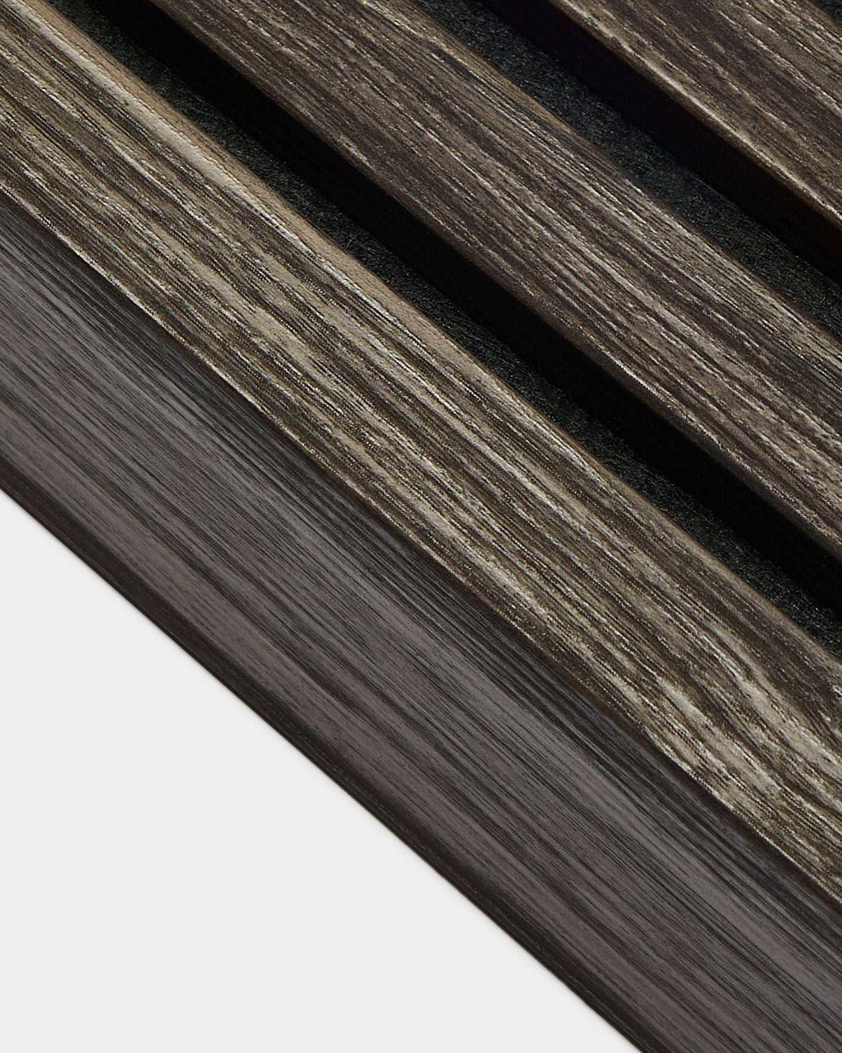 Gros plan sur un détail d’installation de WoodUpp Akupanel en Black Oak, avec des lamelles de finition de 6,7 cm disposées en diagonale et une finition soignée des bords du panneau sur un fond clair.