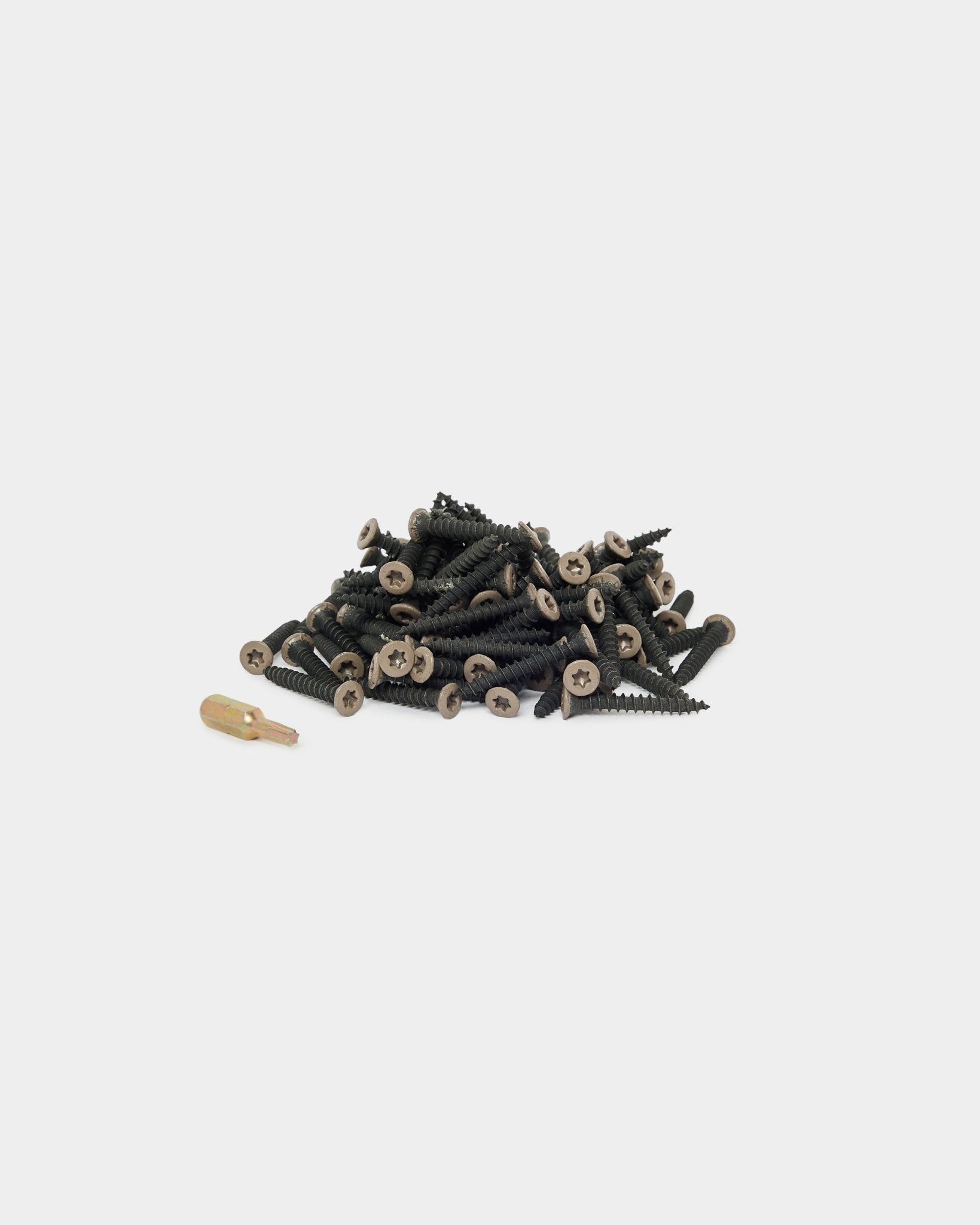 Vis de montage WoodUpp Warm Grey (100 pcs) et embout de tournevis doré disposés sur un fond blanc, adaptés à l’installation de Panneau acoustique ou d’accessoires pour panneaux.