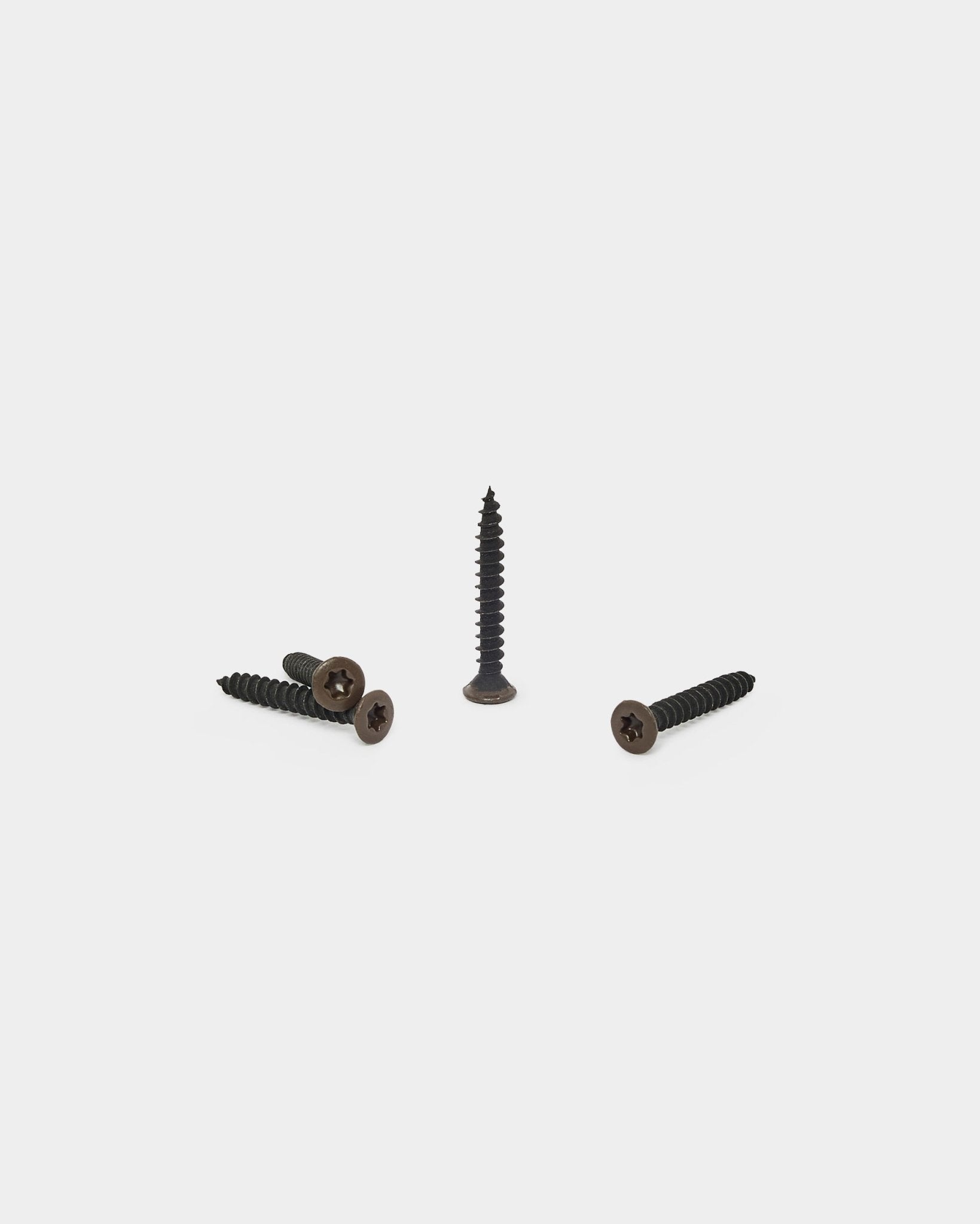 Trois vis WoodUpp bronzed brown, une debout et deux couchées, conçues pour fixer le support en feutre aux panneaux acoustiques Akupanel. Lot de 100.