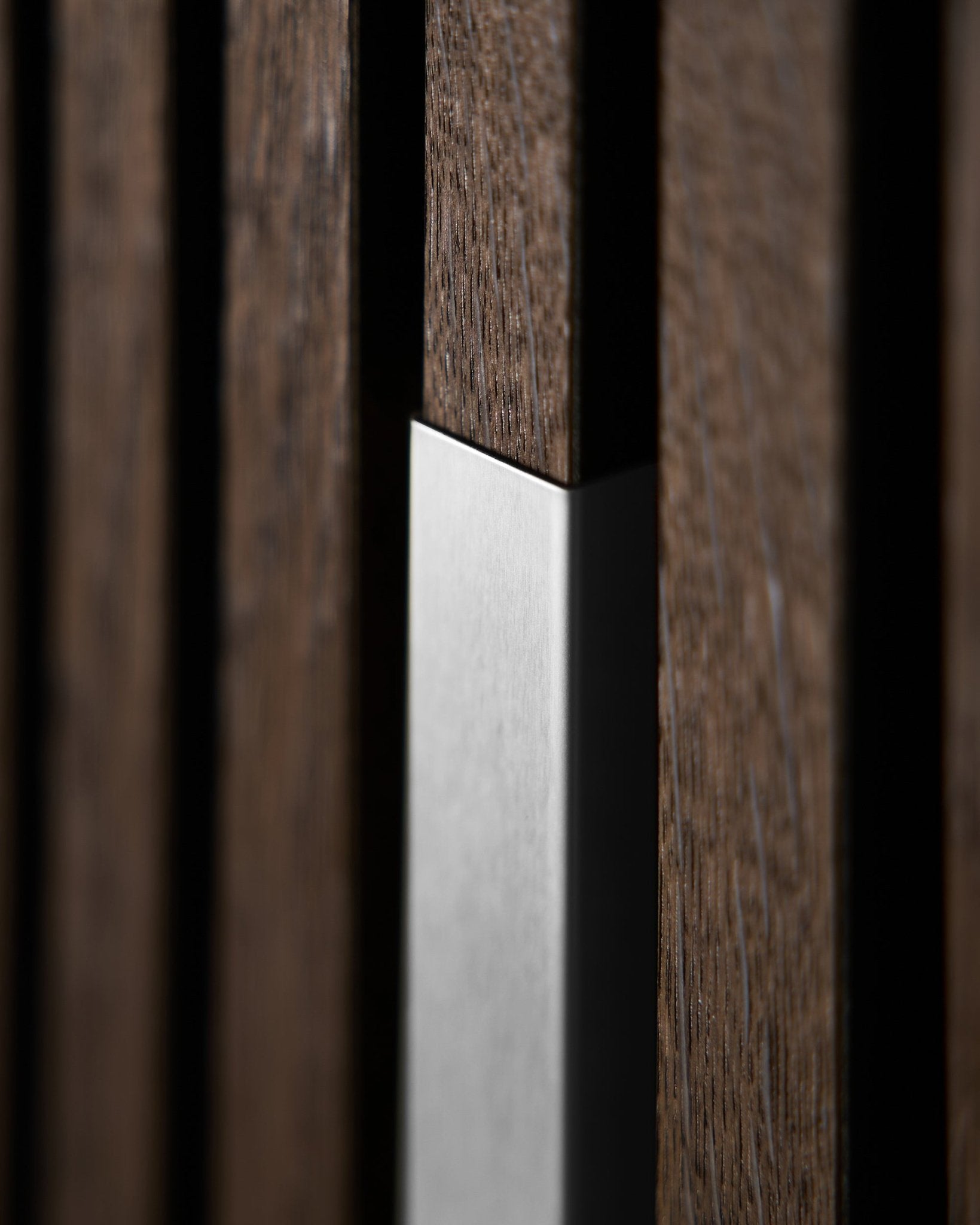Gros plan sur le Liva Akupanel de WoodUpp | Cover — 20 cm en steel poli avec des lattes en bois vertical, mettant en valeur la texture nordique et le contraste de cet accessoire Panneau acoustique.