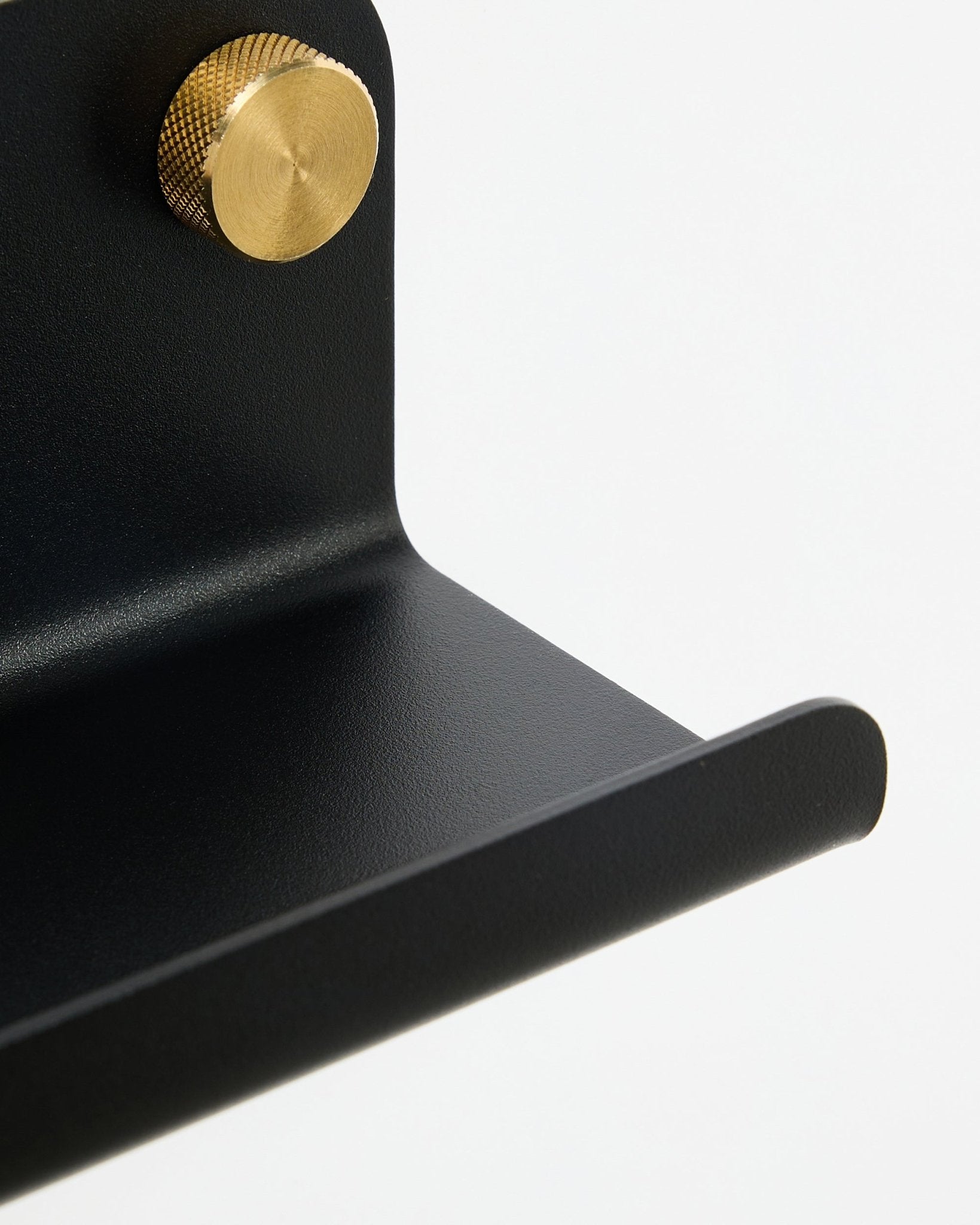 Gros plan sur la Narrow Shelf Norr de WoodUpp en black, 75,9 cm, avec un bouton doré texturé, présentée sur fond blanc.