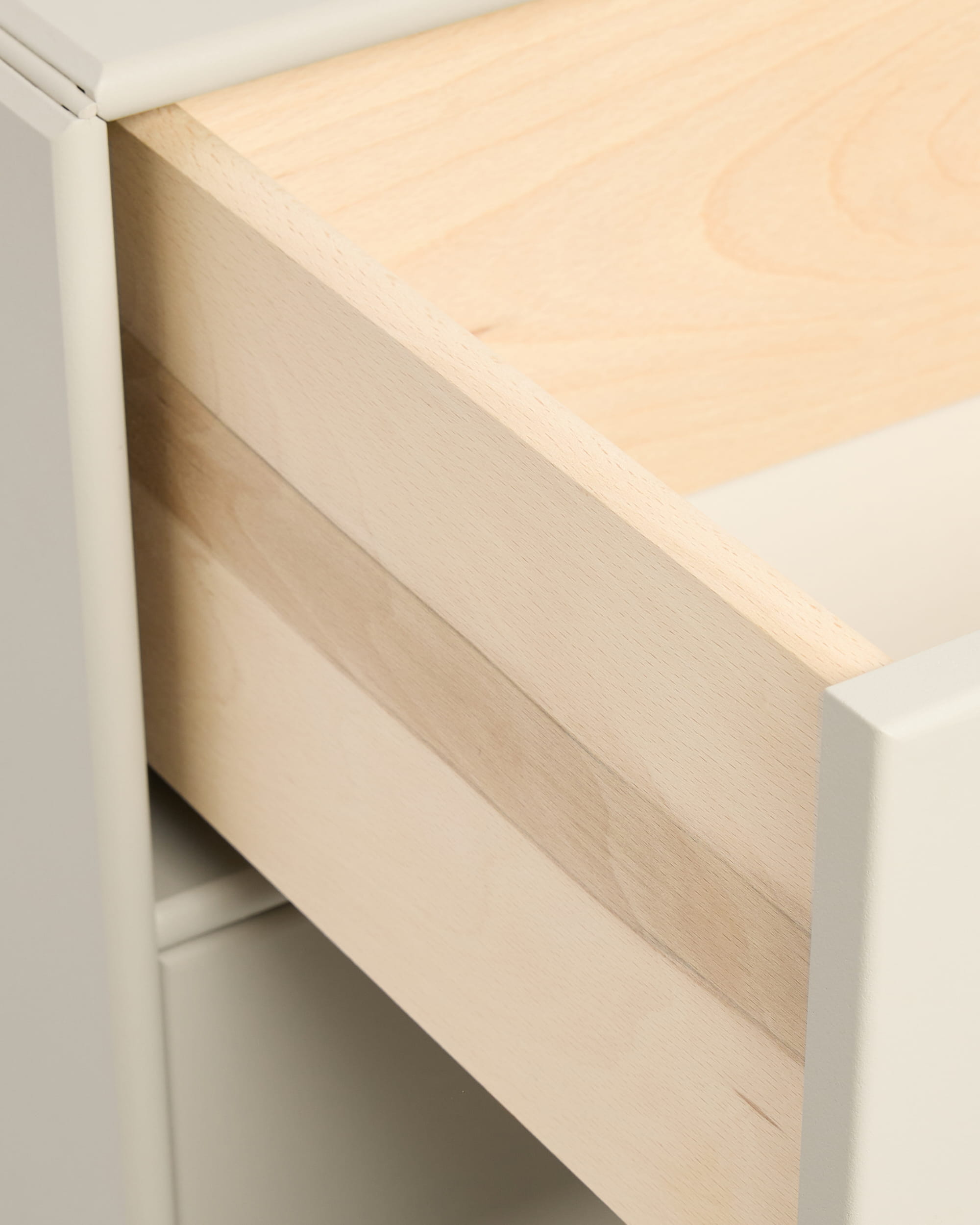 Gros plan sur un tiroir beige « Arka Bookcase » de WoodUpp, partiellement ouvert, intégré dans un meuble blanc, présenté avec des poignées de la collection CREATE.