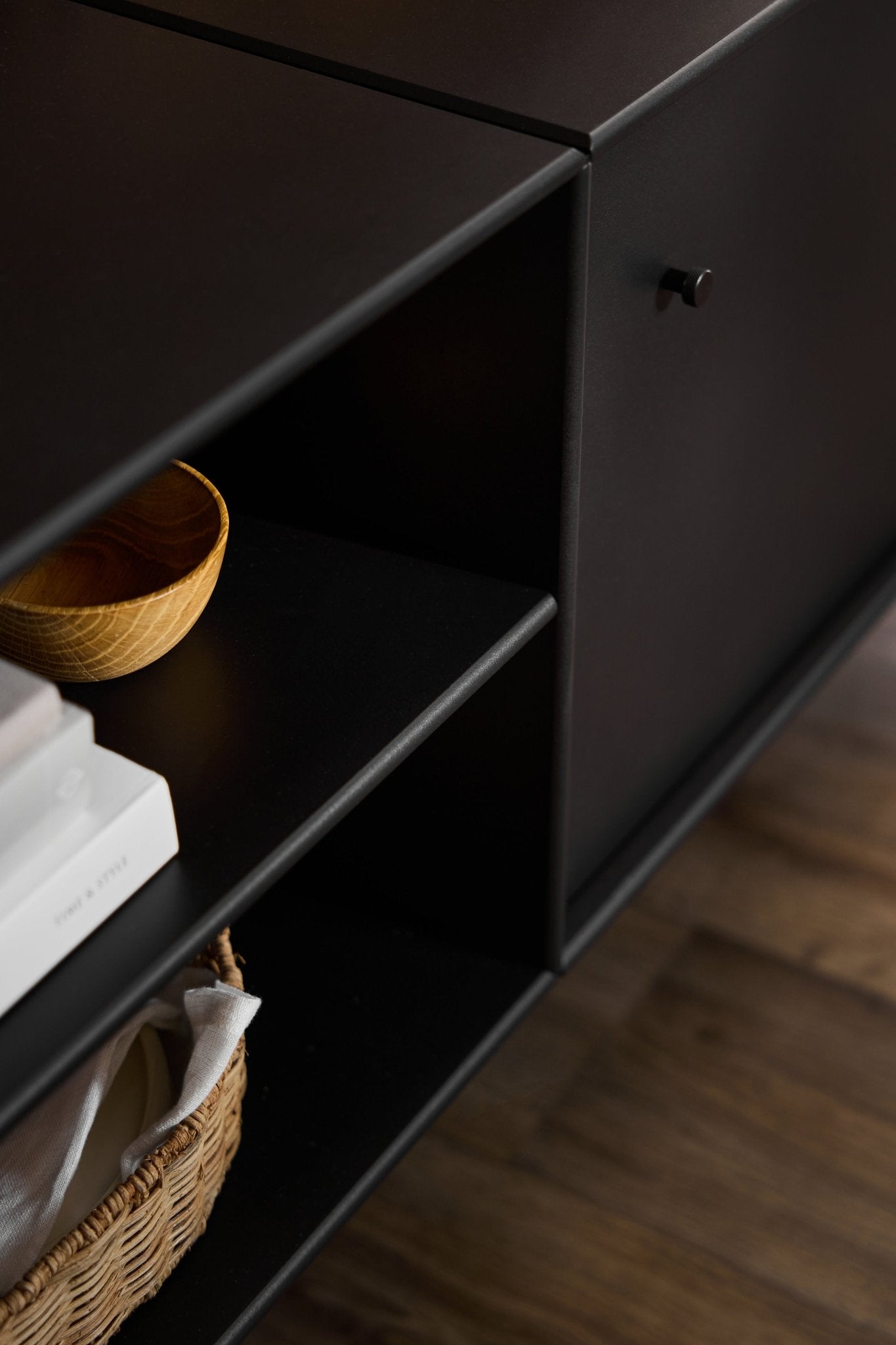 Meuble TV « Black Arka » de WoodUpp, au style minimaliste, conçu pour lorganisation des câbles et le rangement, posé sur un parquet.