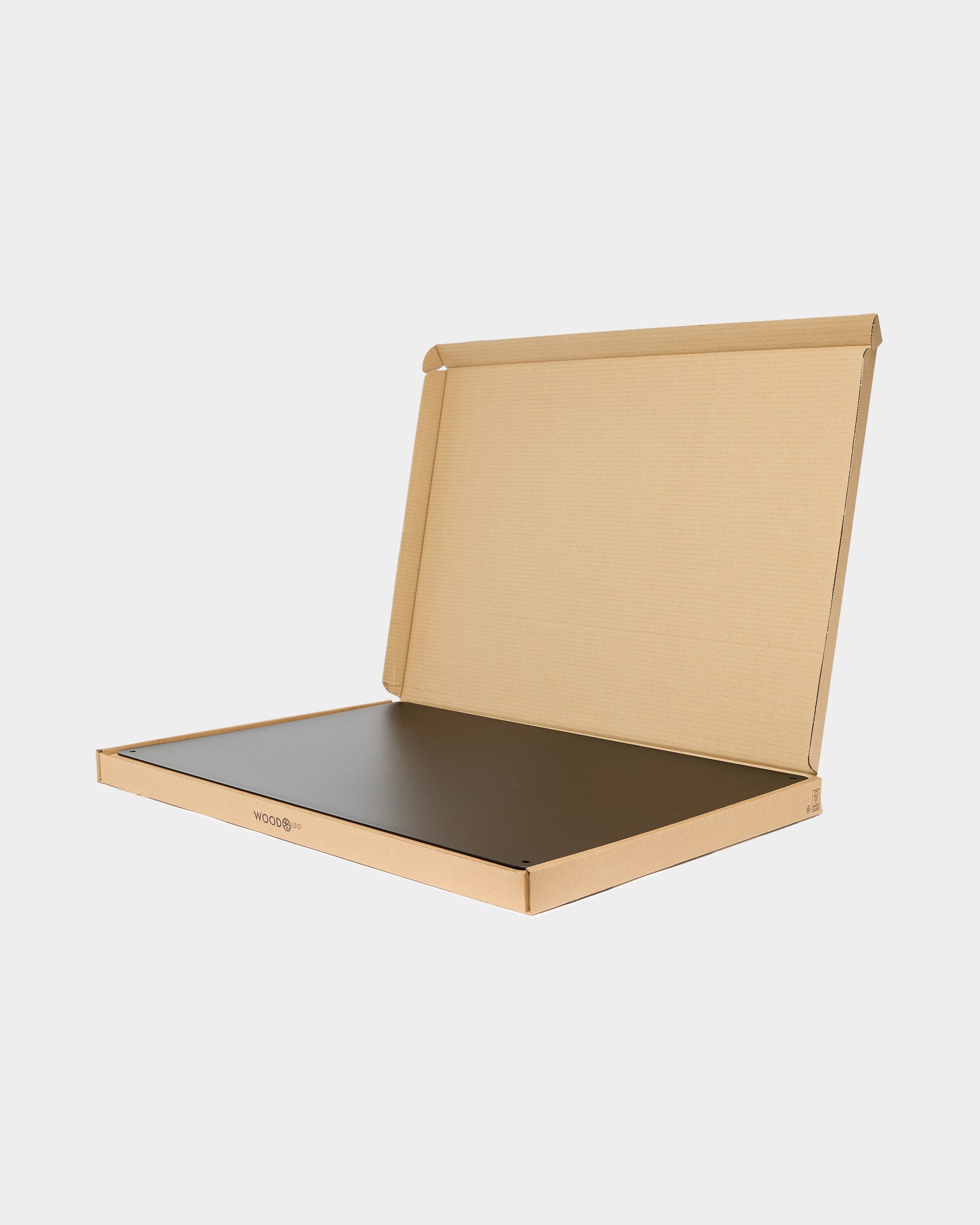 A flat, recyclable cardboard box partially open reveals a thin, dark-colored acoustic panel inside, shown against a plain white background.