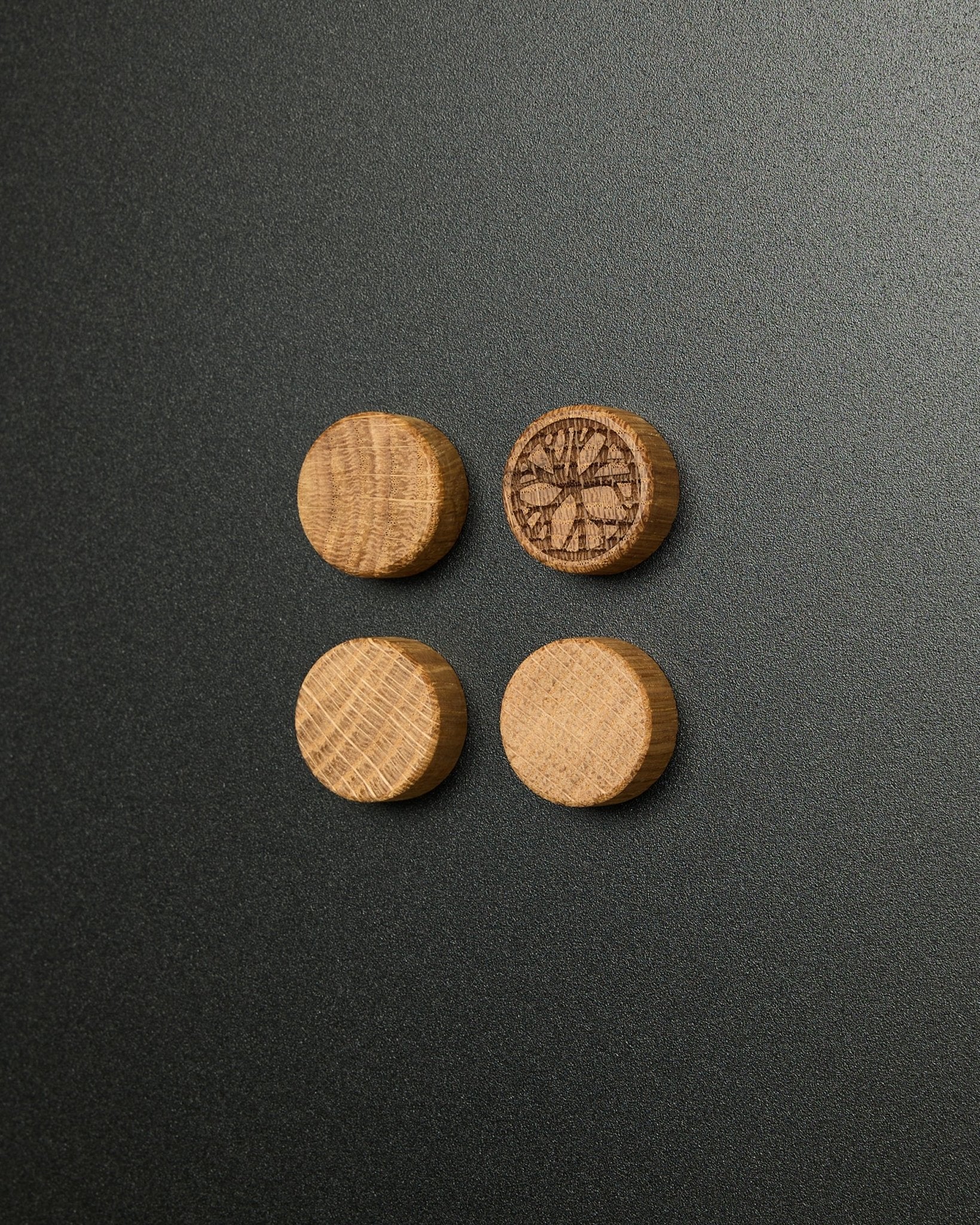 Set de quatre aimants en natural oak massif par WoodUpp, dont un avec un motif de tranche d’agrume sculpté, conçu pour être utilisé avec le Norr Magnetic Board Panneau acoustique.