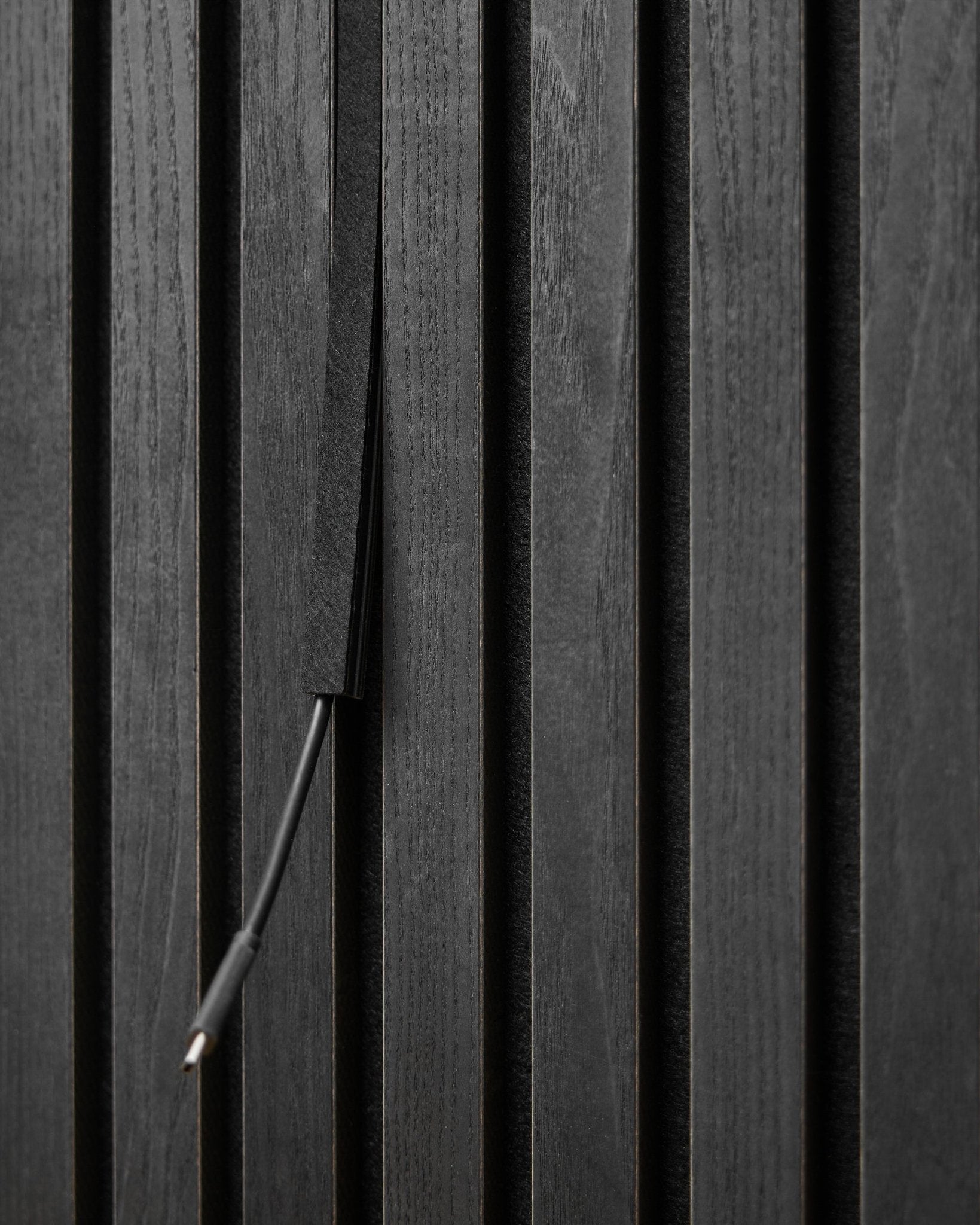 Le cache-câbles Pop-on Dupps (Black, 3 pcs) de WoodUpp dissimule les câbles entre les lattes Akupanel Panneau acoustique pour un rendu net et intégré.