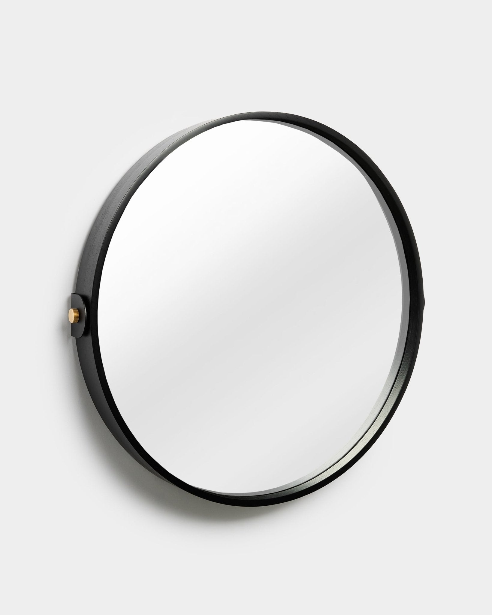 Miroir WoodUpp Linn en Black Oak, avec cadre rond réglable et bouton latéral, présenté sur un fond uni gris clair.