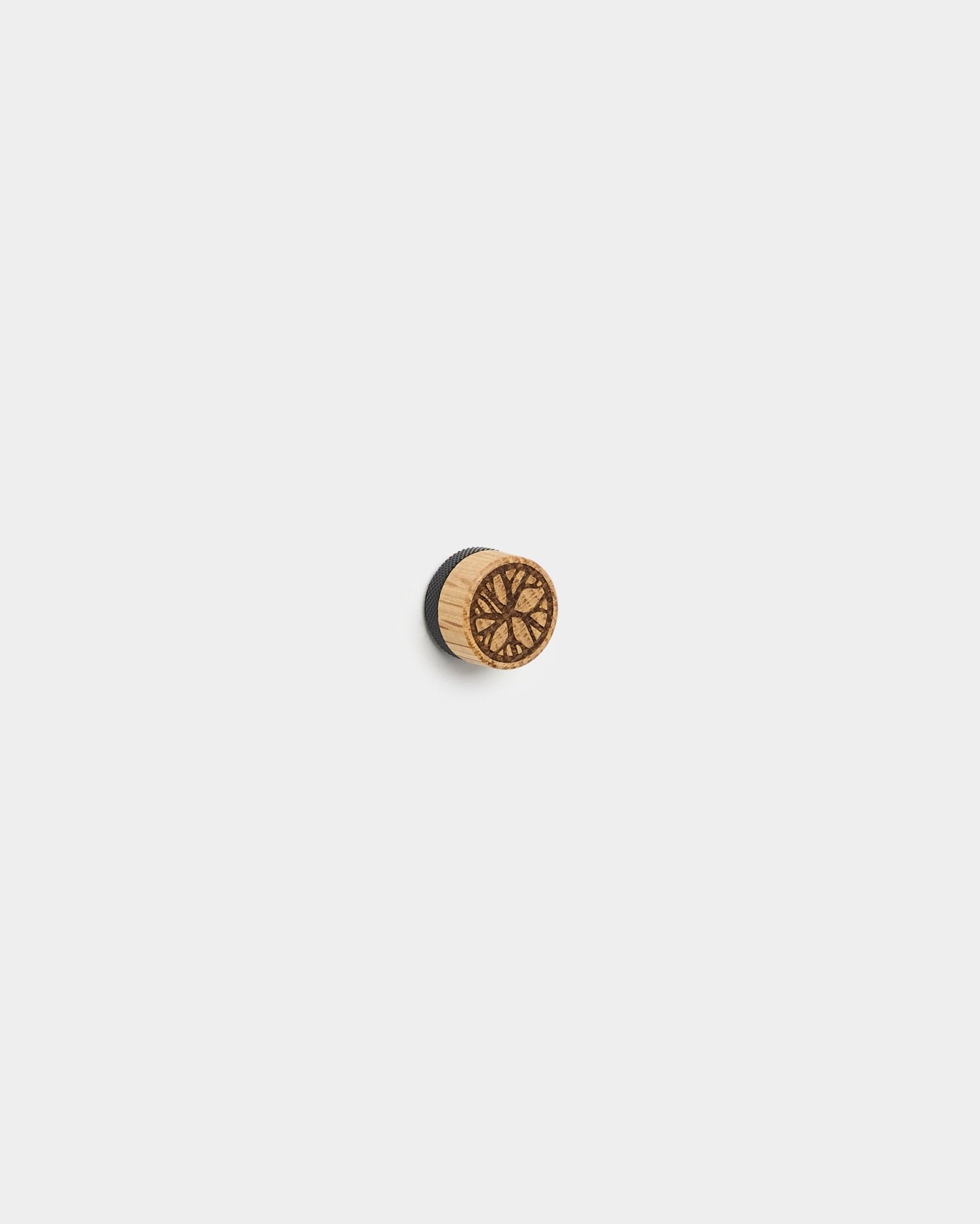 Le set d’aimants pour posters Norr de WoodUpp comprend small, des boutons ronds en chêne au motif géométrique, conçus pour afficher des photos sur des panneaux acoustiques blancs ou des panneaux à lattes.