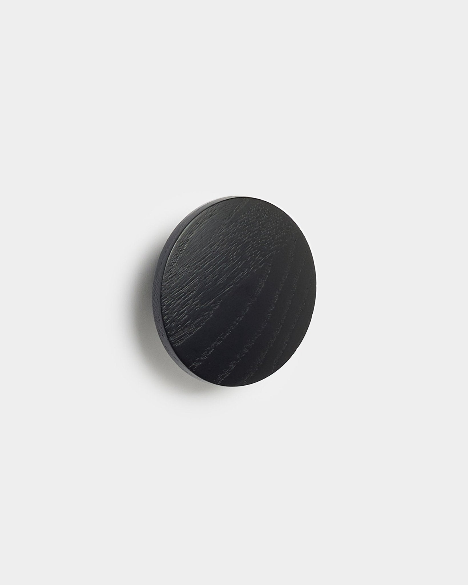 Le Linn | Single Hanger en black oak de WoodUpp, un accessoire rond pour les panneaux acoustiques Akupanel, présenté sur un fond blanc uni.