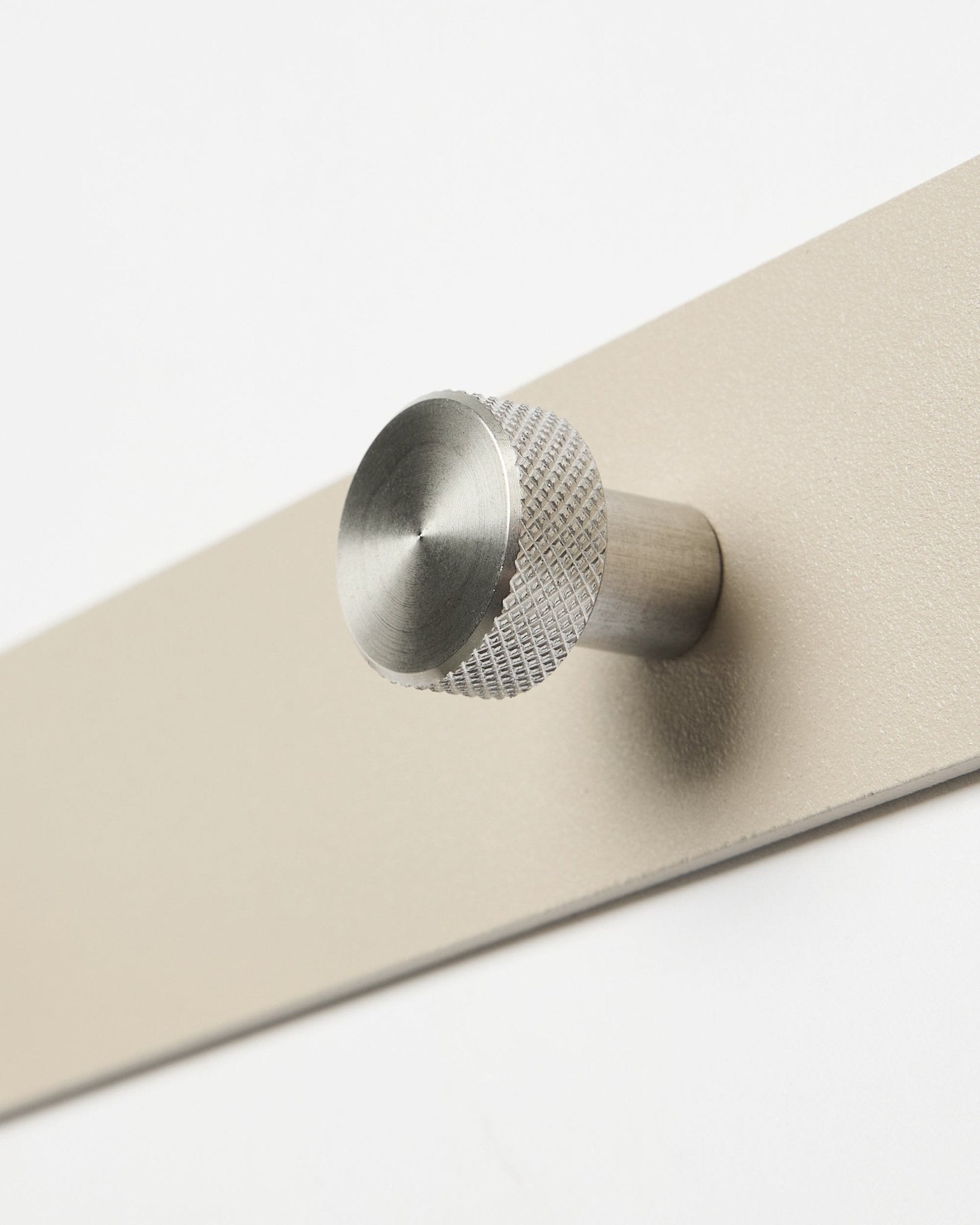 Gros plan sur la patère murale WoodUpp Norr en beige et acier inoxydable steel, X7, conçue comme accessoire pour les panneaux acoustiques en bois Akupanel ou pour organiser un couloir.