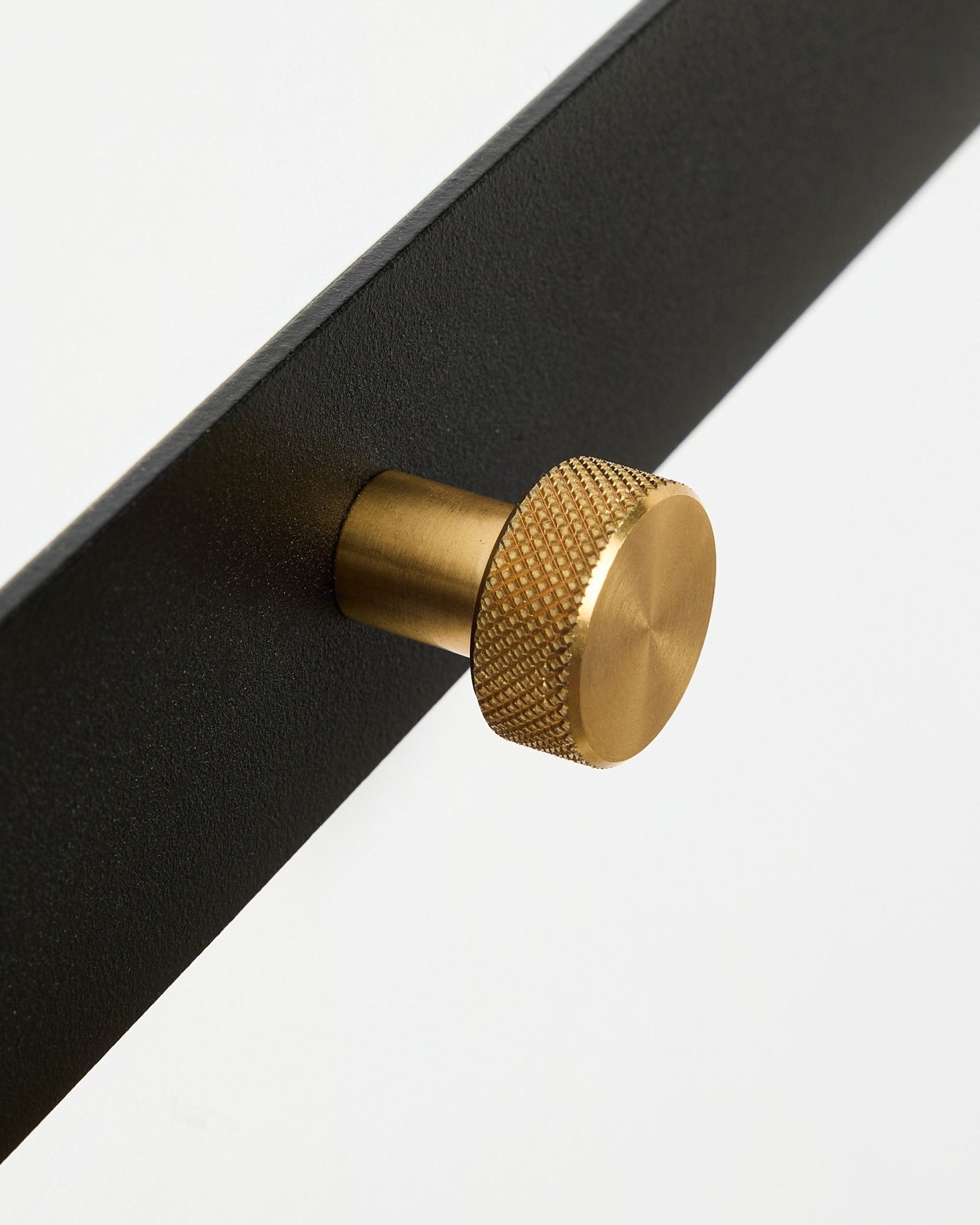 Gros plan sur le porte-manteau Norr Coat Hook Rack X5 de WoodUpp, avec une finition thermolaquée black steel et des patères rondes texturées brass, sur fond blanc.