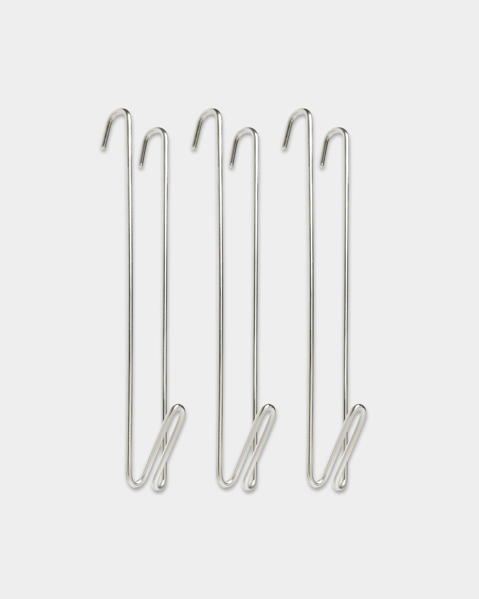 Trois rallonges de tringle de penderie en acier inoxydable WoodUpp Alva steel BM1 à crochet fil, conçues pour ajouter de l’espace de suspension aux côtés des panneaux acoustiques en bois.