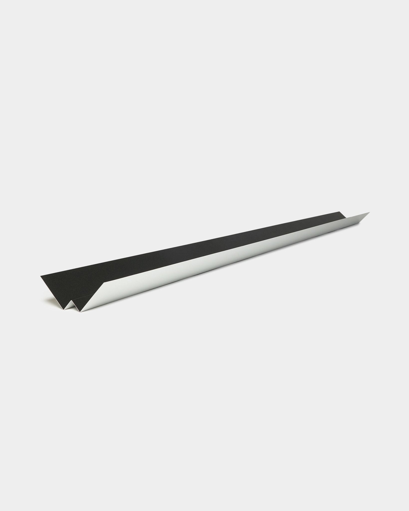 Design minimaliste avec black et avion en papier blanc, faisant référence aux lignes épurées et au profil géométrique du panneau de façade Aluwood Inside Corner de WoodUpp, 240 cm.