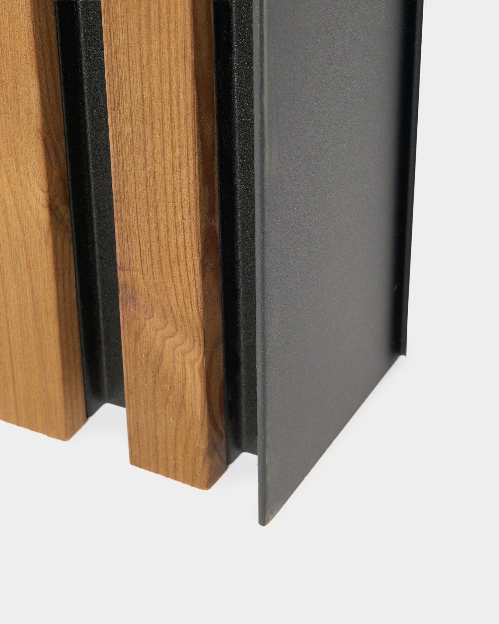 Gros plan du panneau de façade WoodUpp Aluwood, 240 cm, avec des lattes en bois vertical et un profilé en aluminium thermolaqué foncé pour une installation en extérieur.