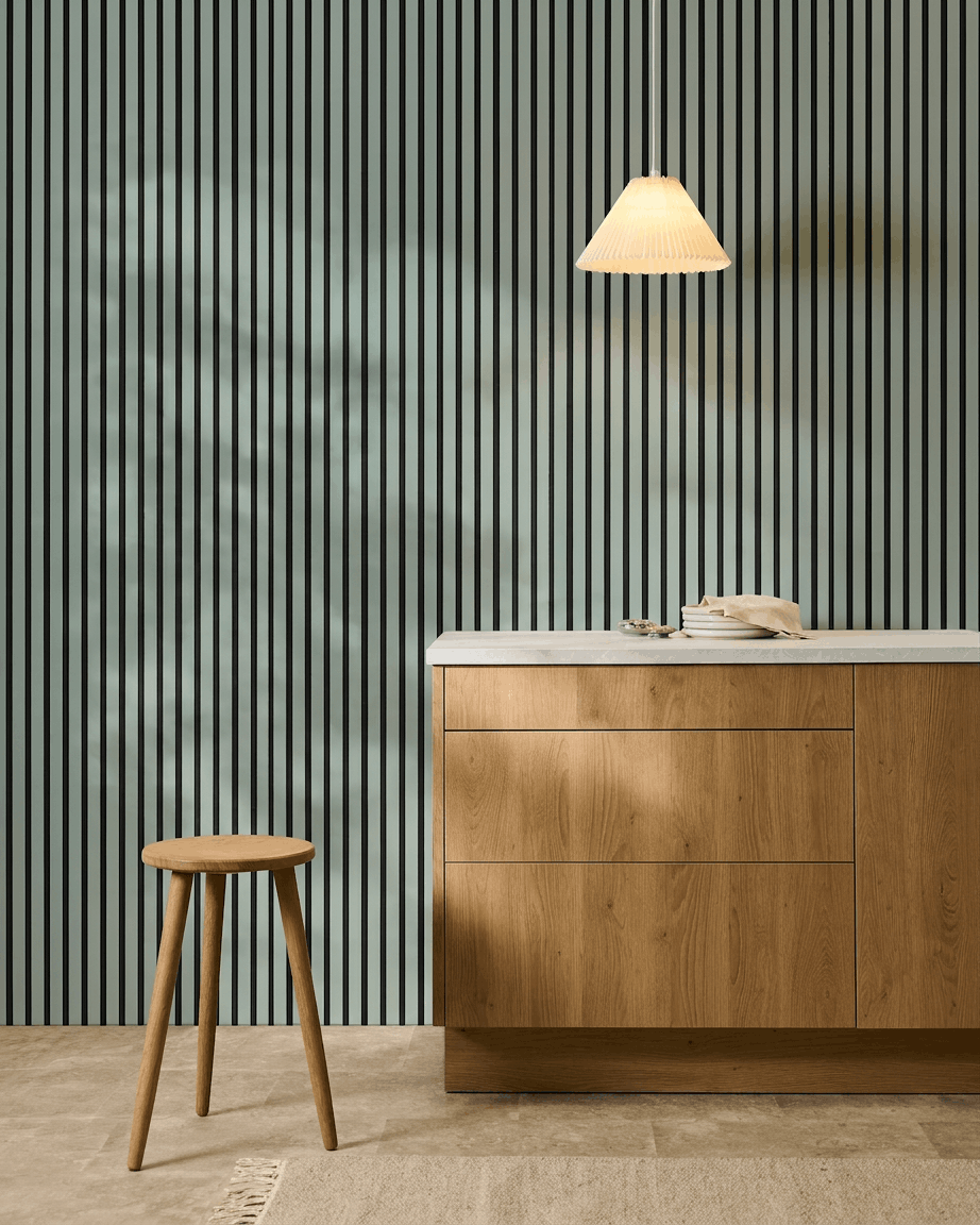 Cuisine nordique minimaliste avec un tabouret en bois, un meuble et WoodUpp Akupanel Panneau acoustique en coloris Cloud avec feutre black (240x60cm) pour le confort acoustique.