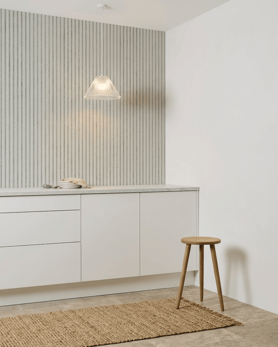 Cuisine minimaliste avec des placards blancs, un tabouret en bois, un tapis tissé et un panneau acoustique WoodUpp Akupanel Snow Panneau acoustique installé pour l’absorption acoustique.