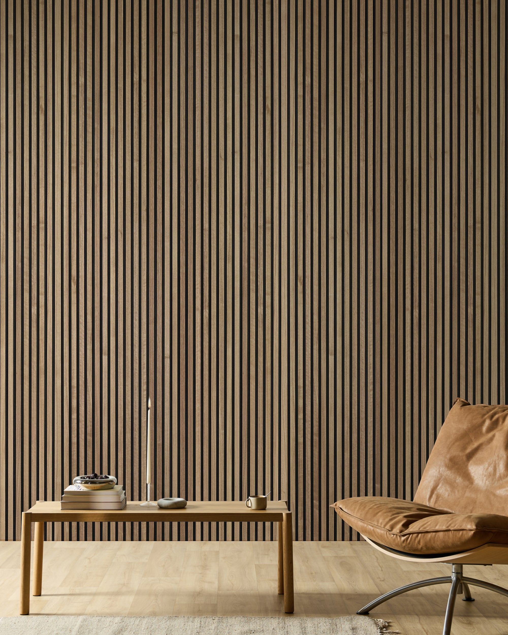 Pièce minimaliste avec un fauteuil en cuir, un banc en bois, des livres, une bougie et un mur d'accent en bois à lames acoustiques Akupanel moderne dans des tons neutres.
