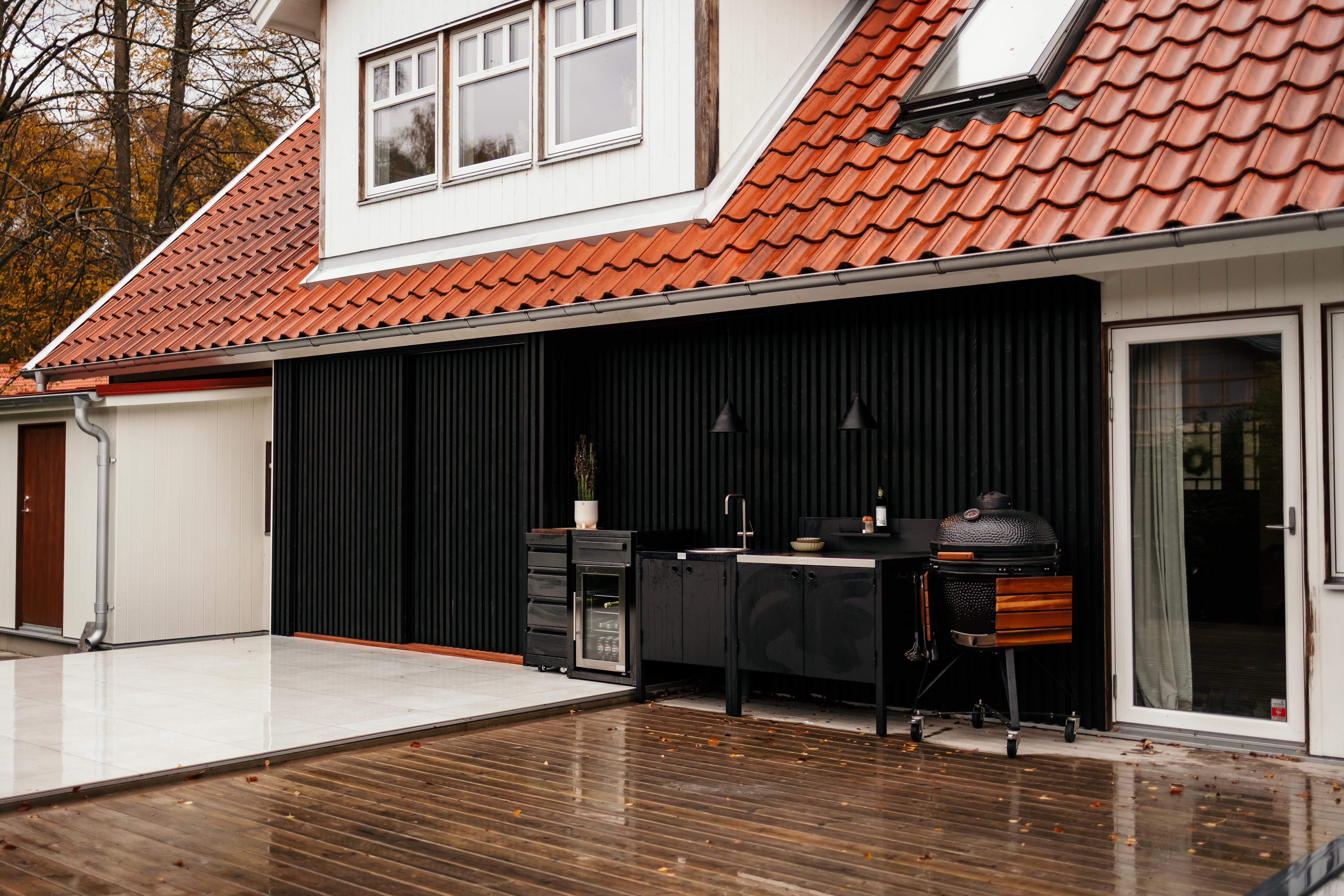Black Aluwood aluminium slat cladding on exterior wall beneath red tiled roof.